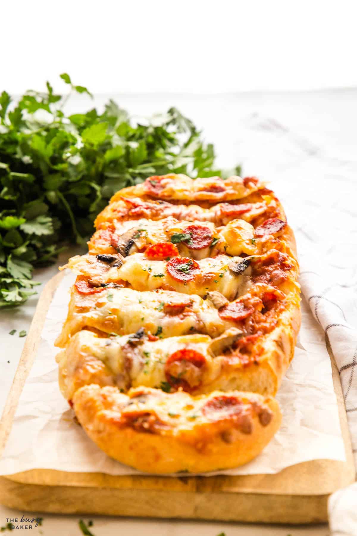 french bread pizza sliced on a board