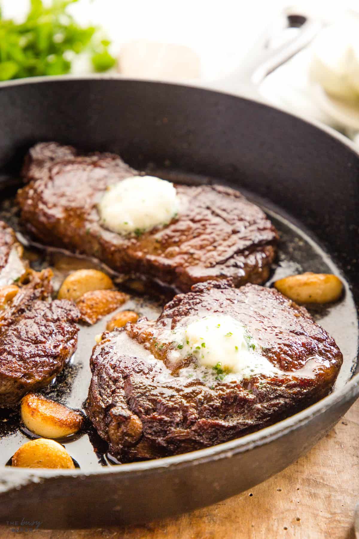 ribeye steak with garlic butter in a cast iron skillet