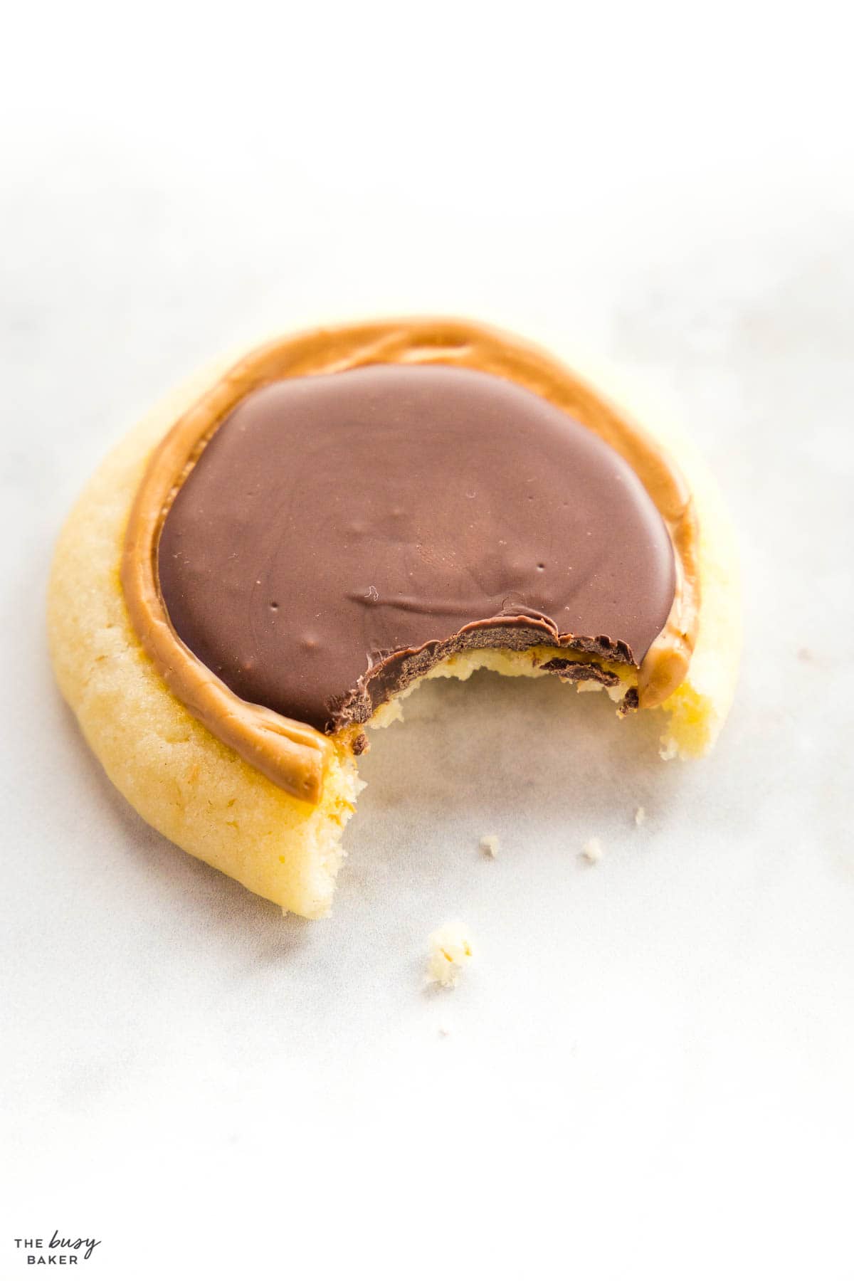 chocolate caramel shortbread cookie with a bite out of it