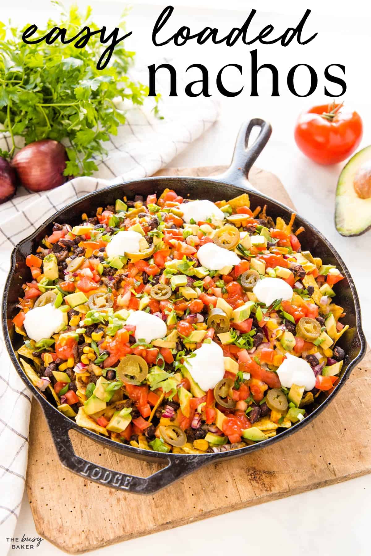 Loaded nachos in cast iron pan with text