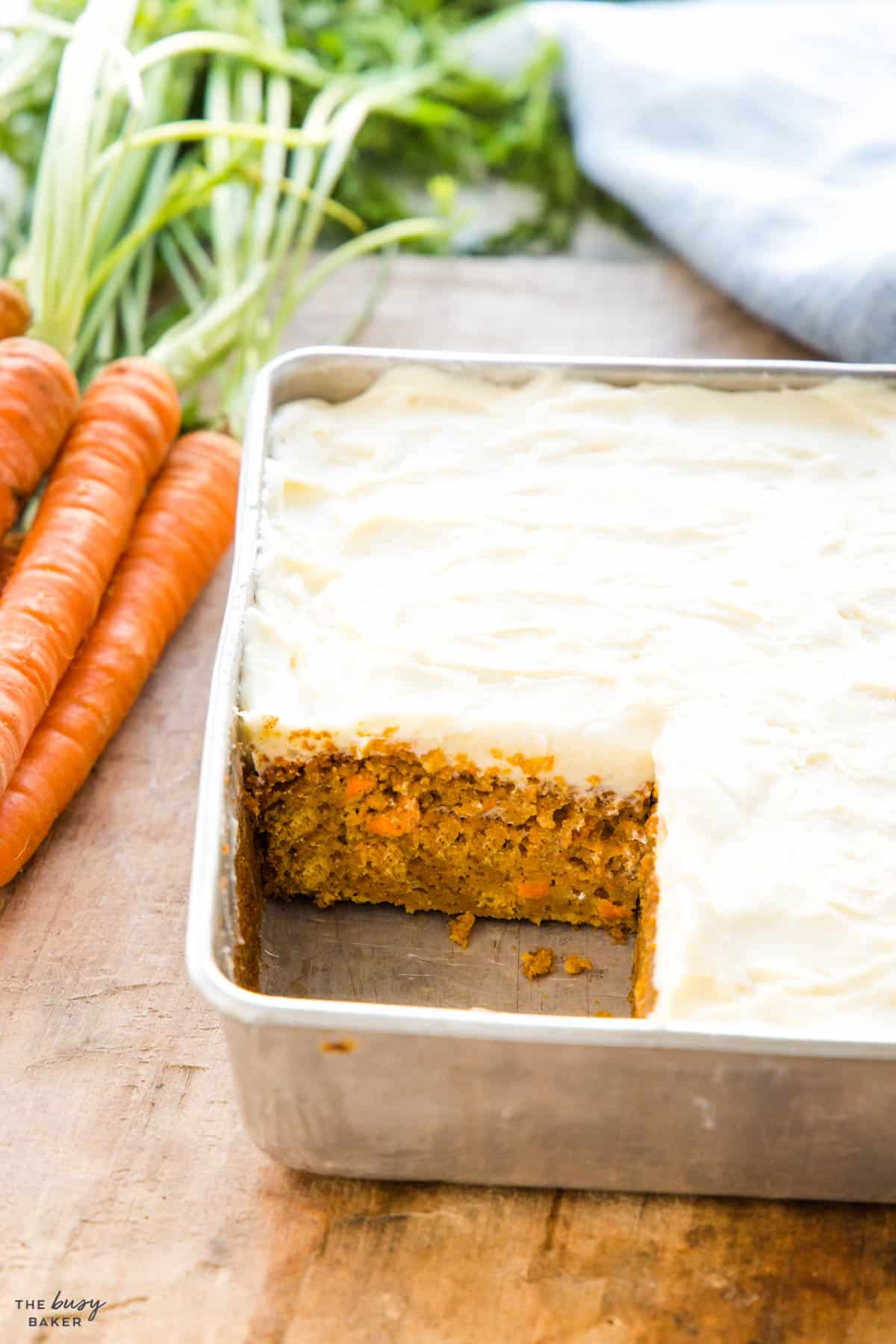 easy carrot cake in a cake pan with cream cheese frosting