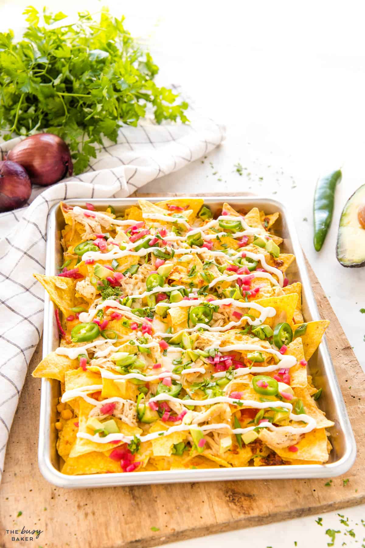 sheet pan full of tortilla chips and veggies and chicken toppings