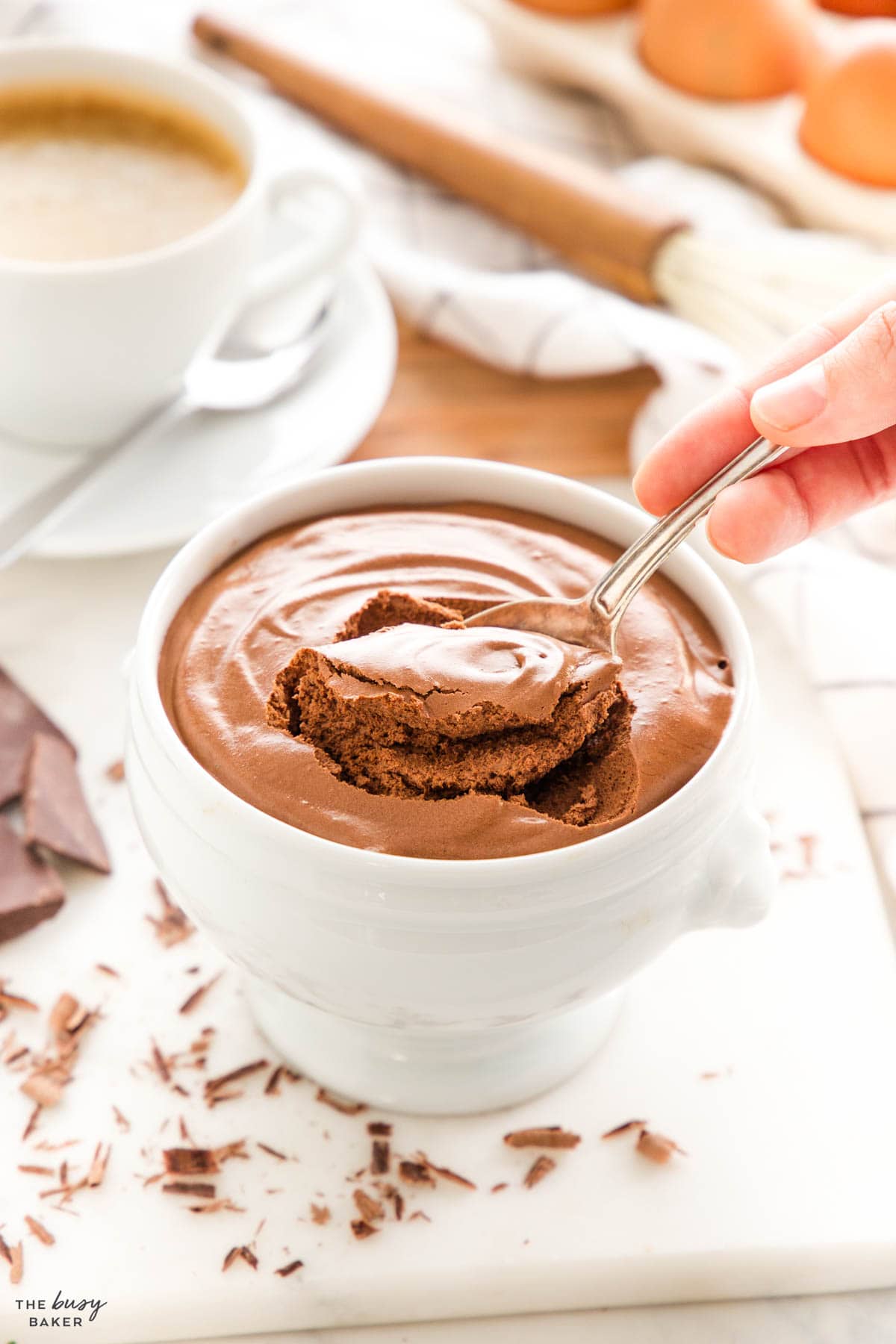 a hand making a spoonful of chocolate mousse with a vintage spoon (mousse au chocolat)