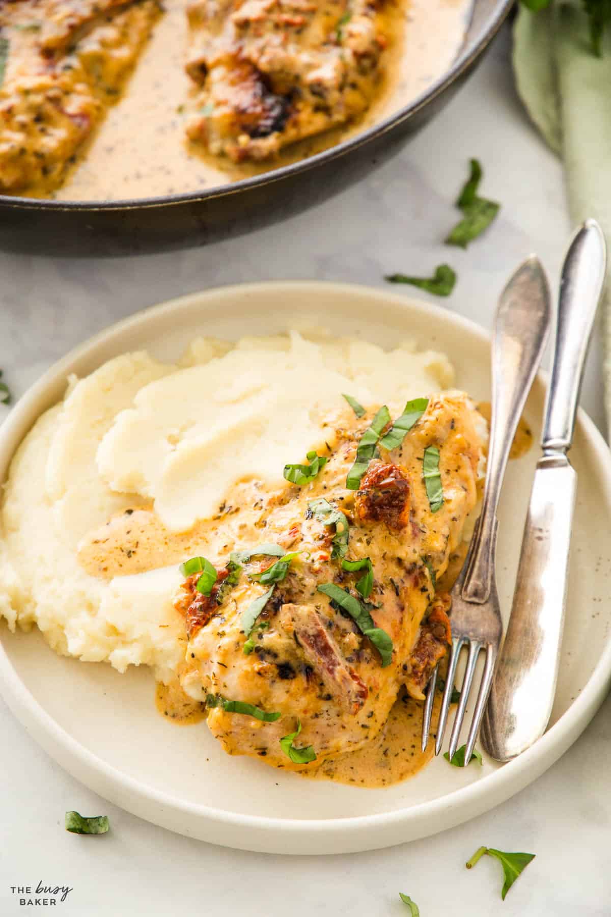 Marry Me Chicken serving on a plate with mashed potatoes and basil