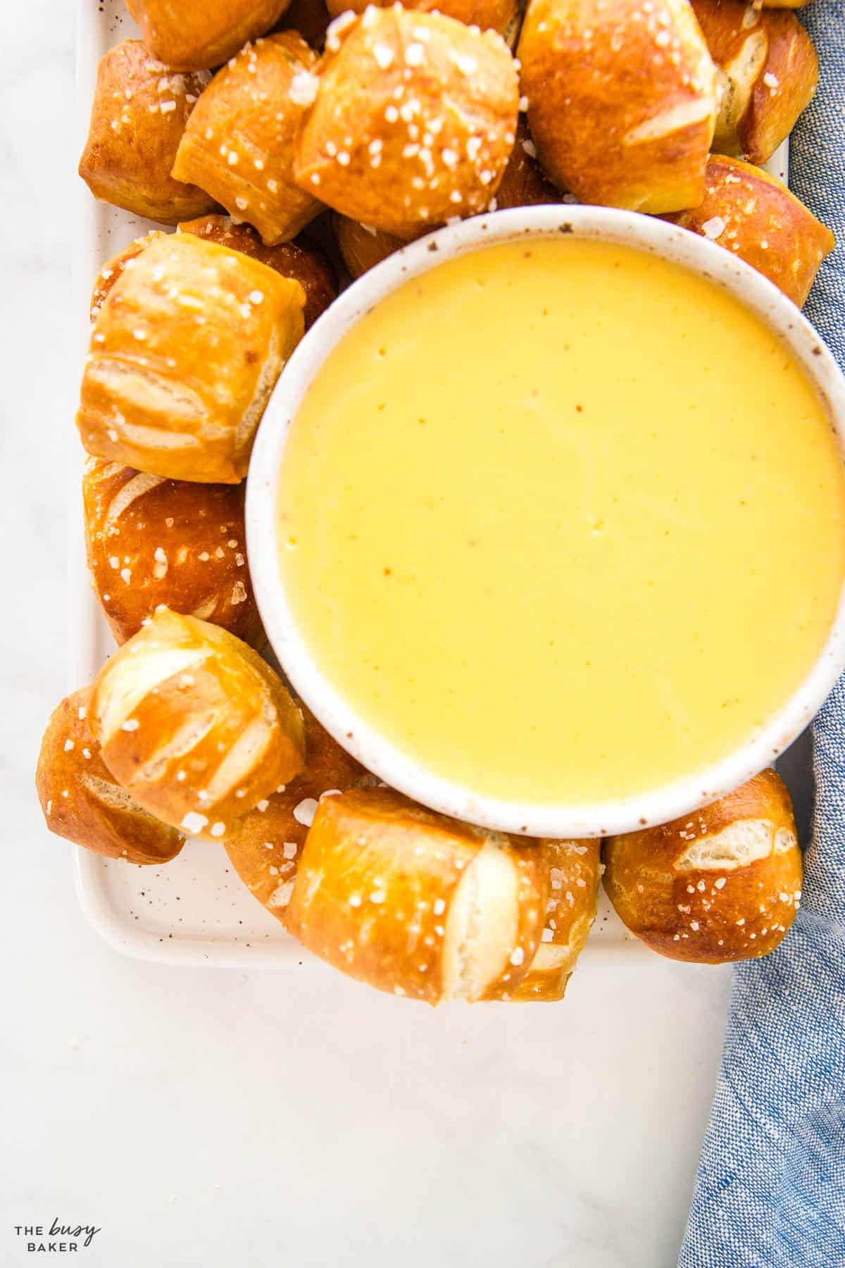 cheddar cheese sauce in a bowl with pretzel bites