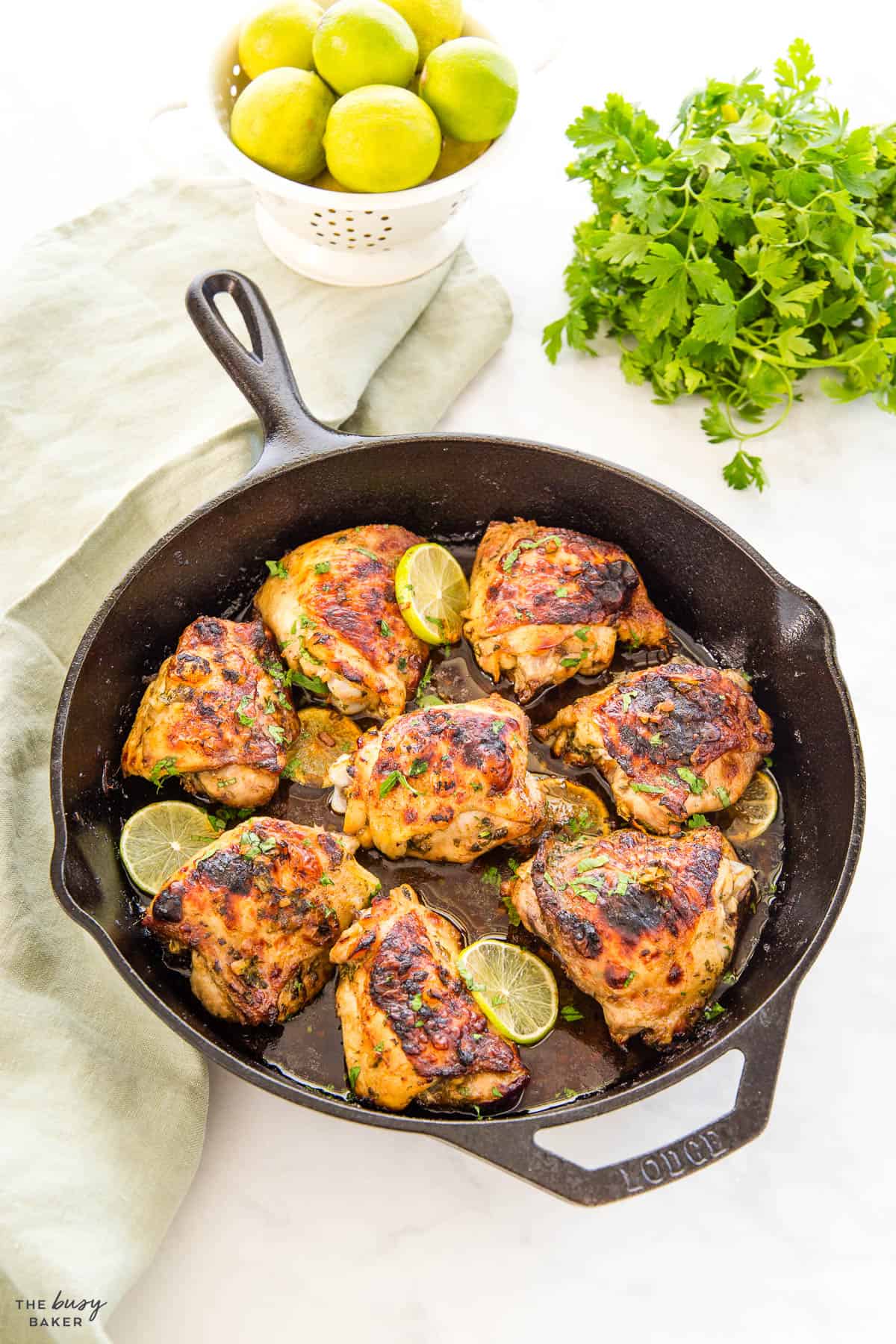 chicken thighs with cilantro and lime in a cast iron skillet