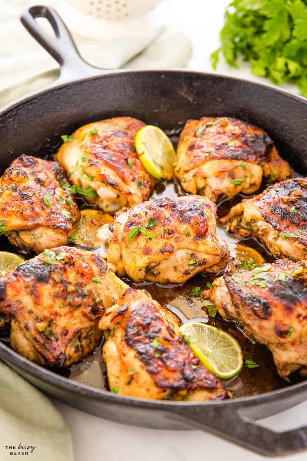 chicken thighs with cilantro and lime in a cast iron skillet