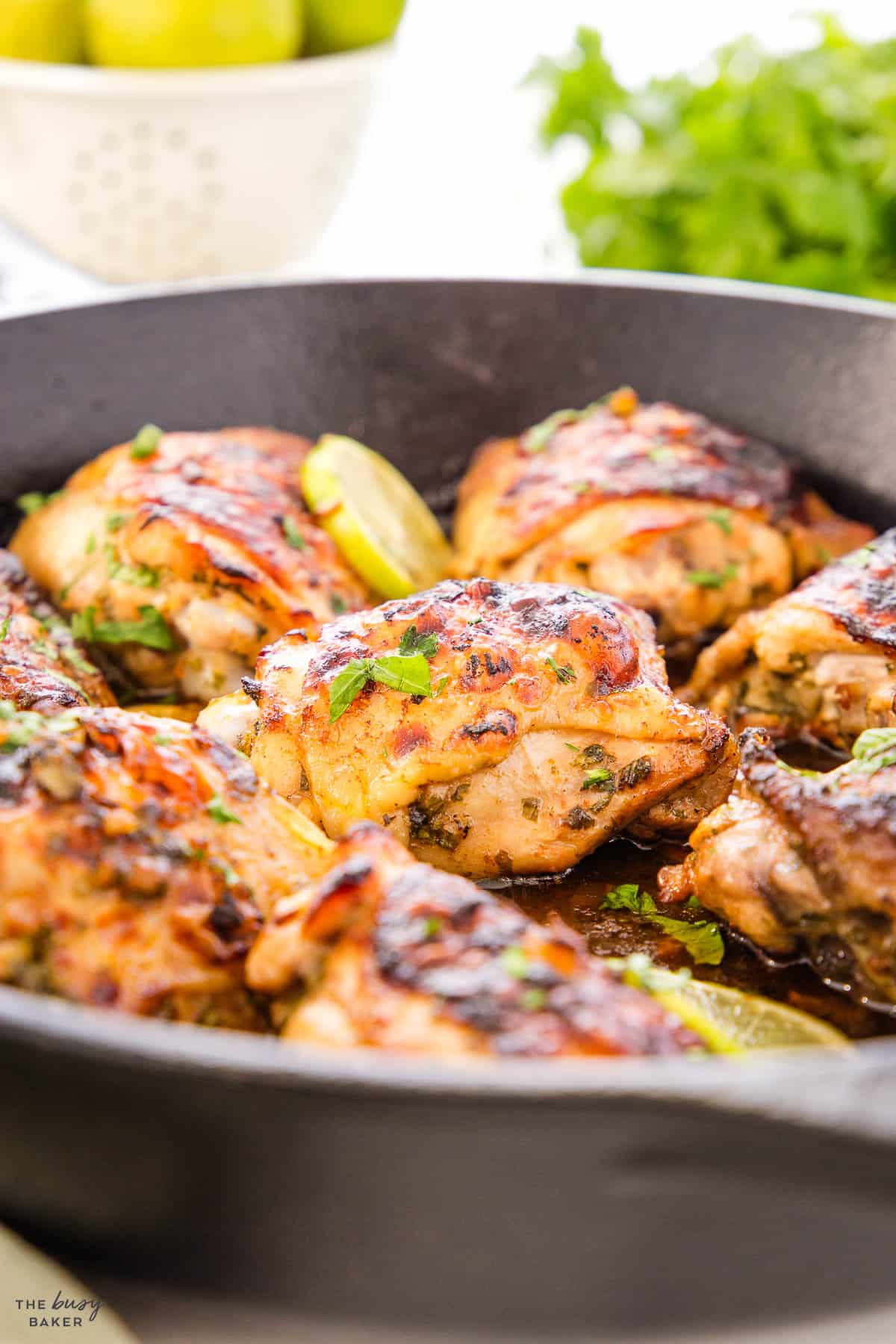 chicken thighs with cilantro and lime in a cast iron skillet