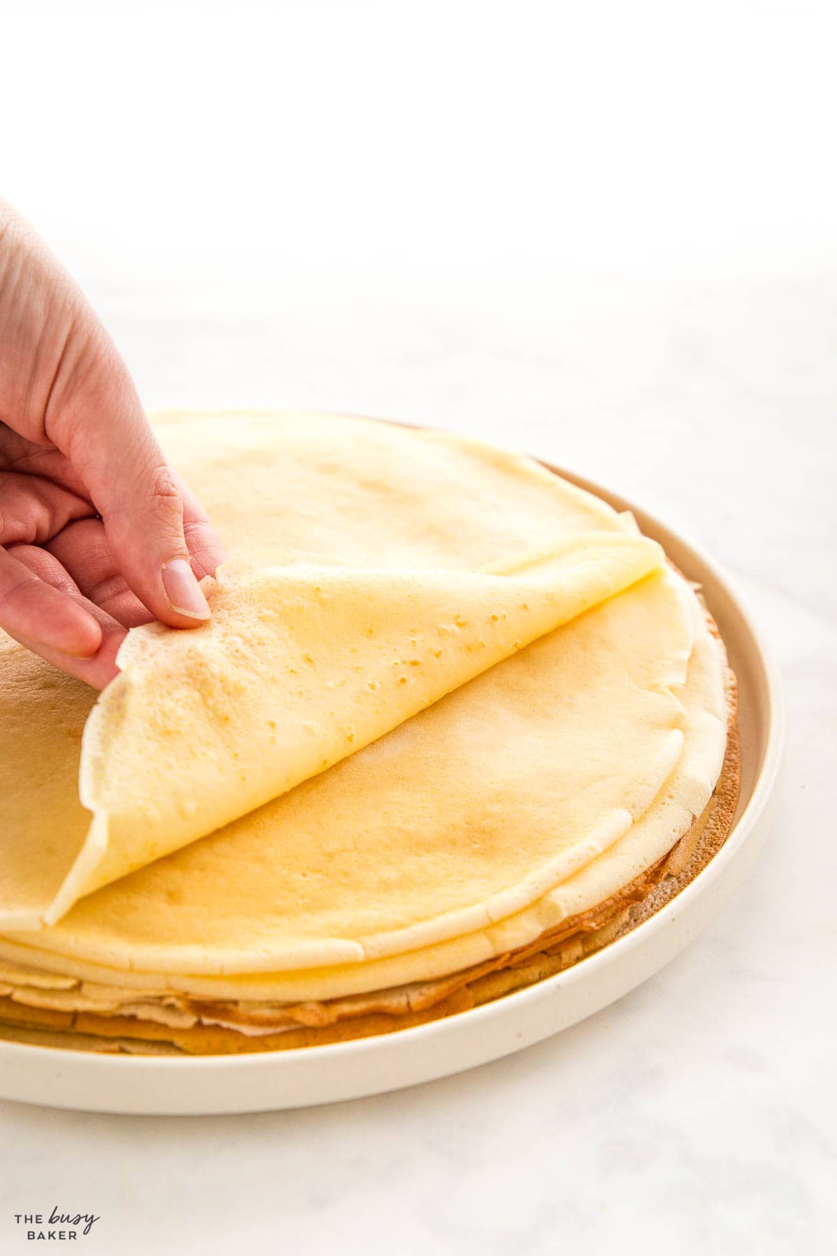 hand pulling a crepe off a stack