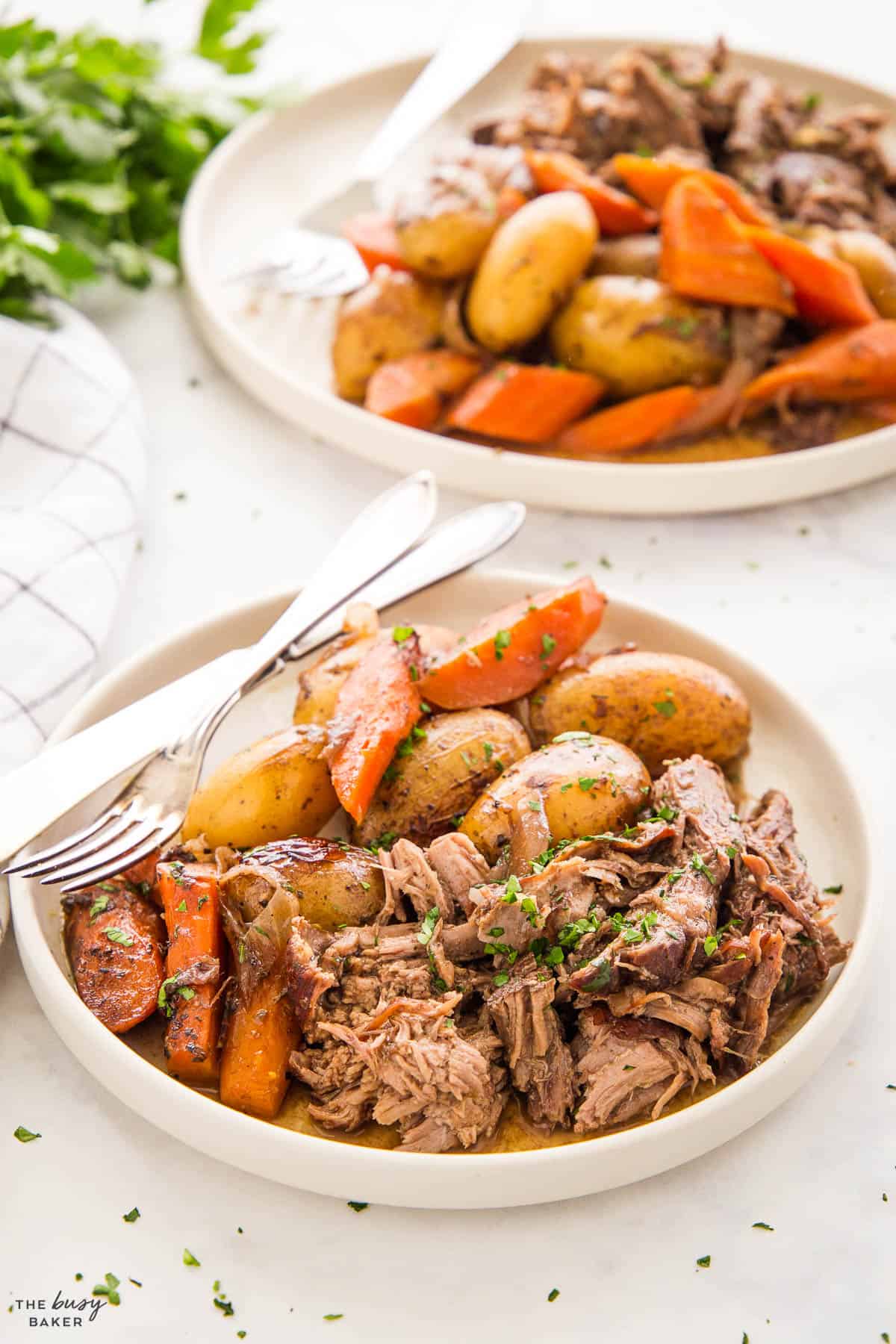 shredded beef pot roast on a plate with carrots and potatoes and gravy