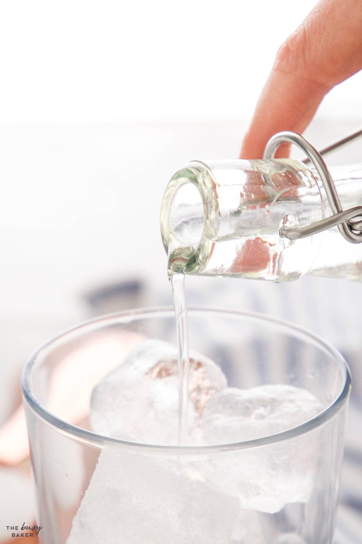 simple syrup pouring into a drink with ice