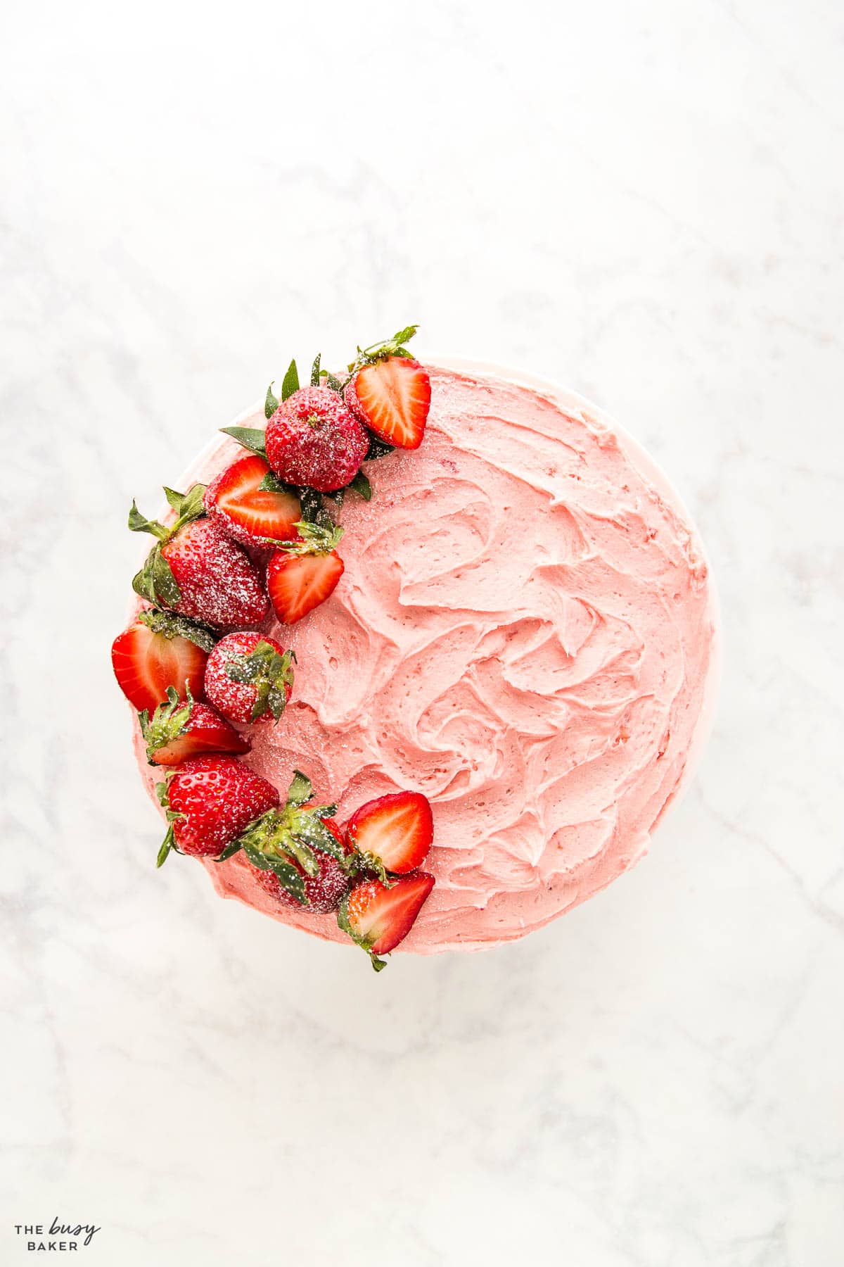 overhead image: strawberry cake with strawberry buttercream and fresh strawberries