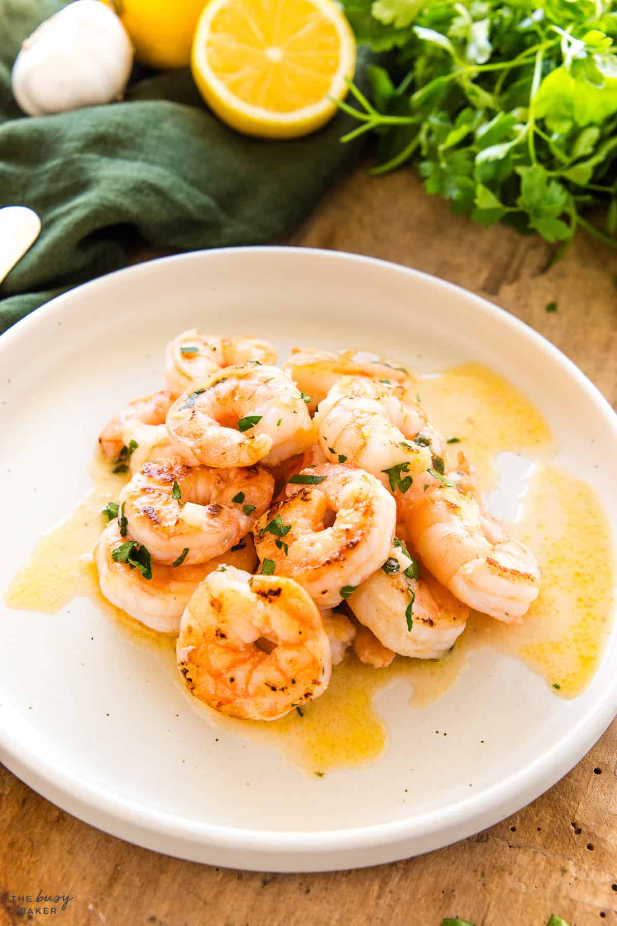 garlic shrimp recipe on a plate with fresh herbs