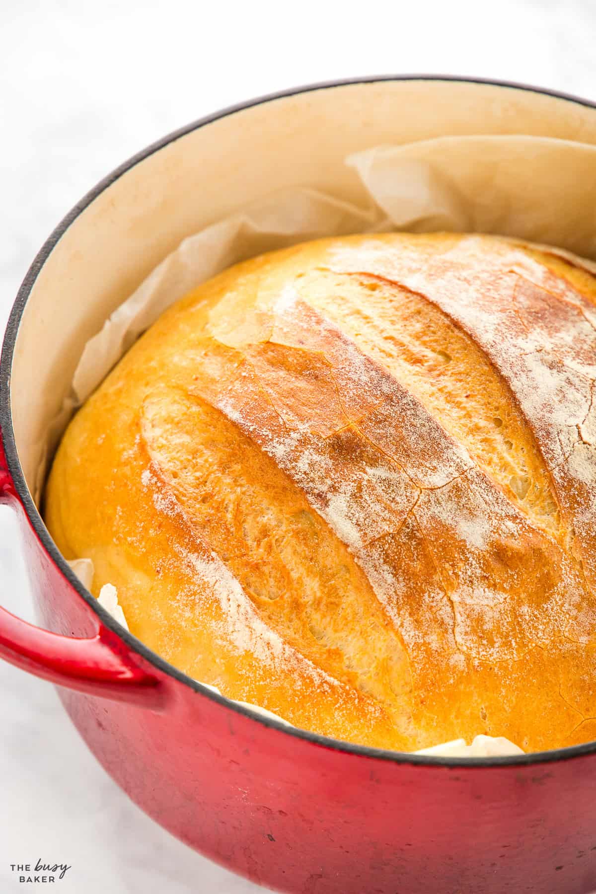 red cast iron pot with a loaf of potato bread