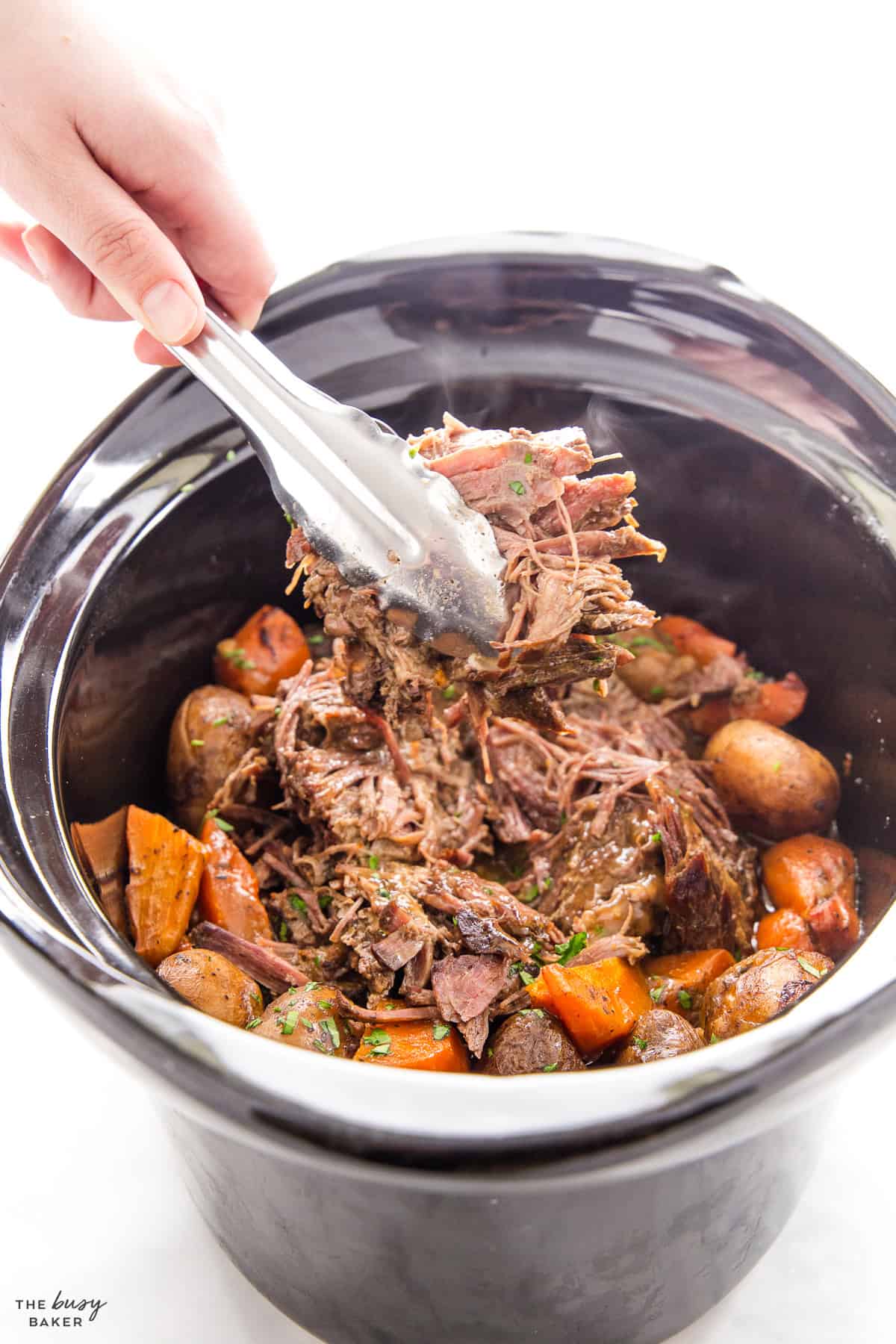 hand serving beef with tongs