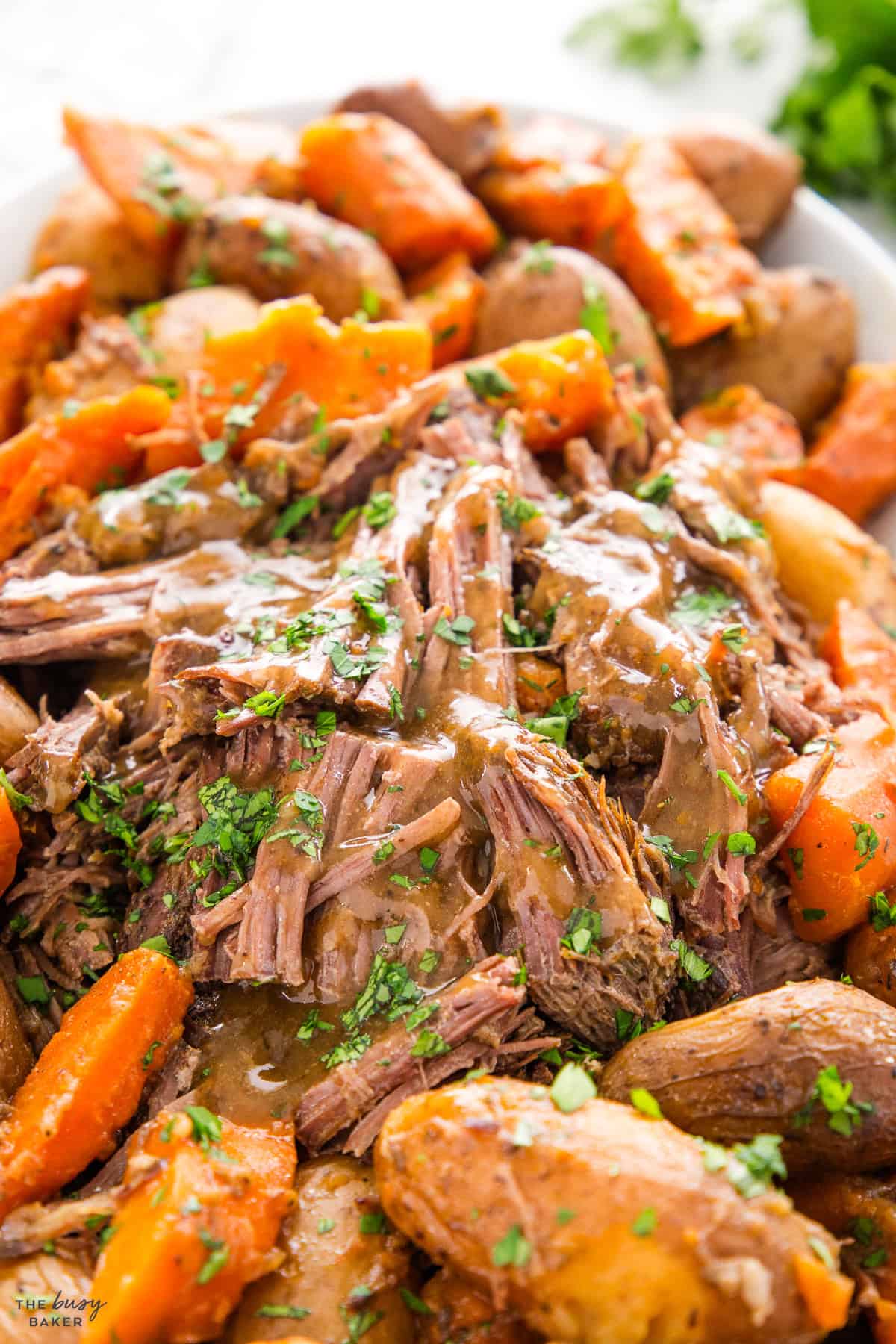 crock pot pot roast on a platter with gravy and vegetables