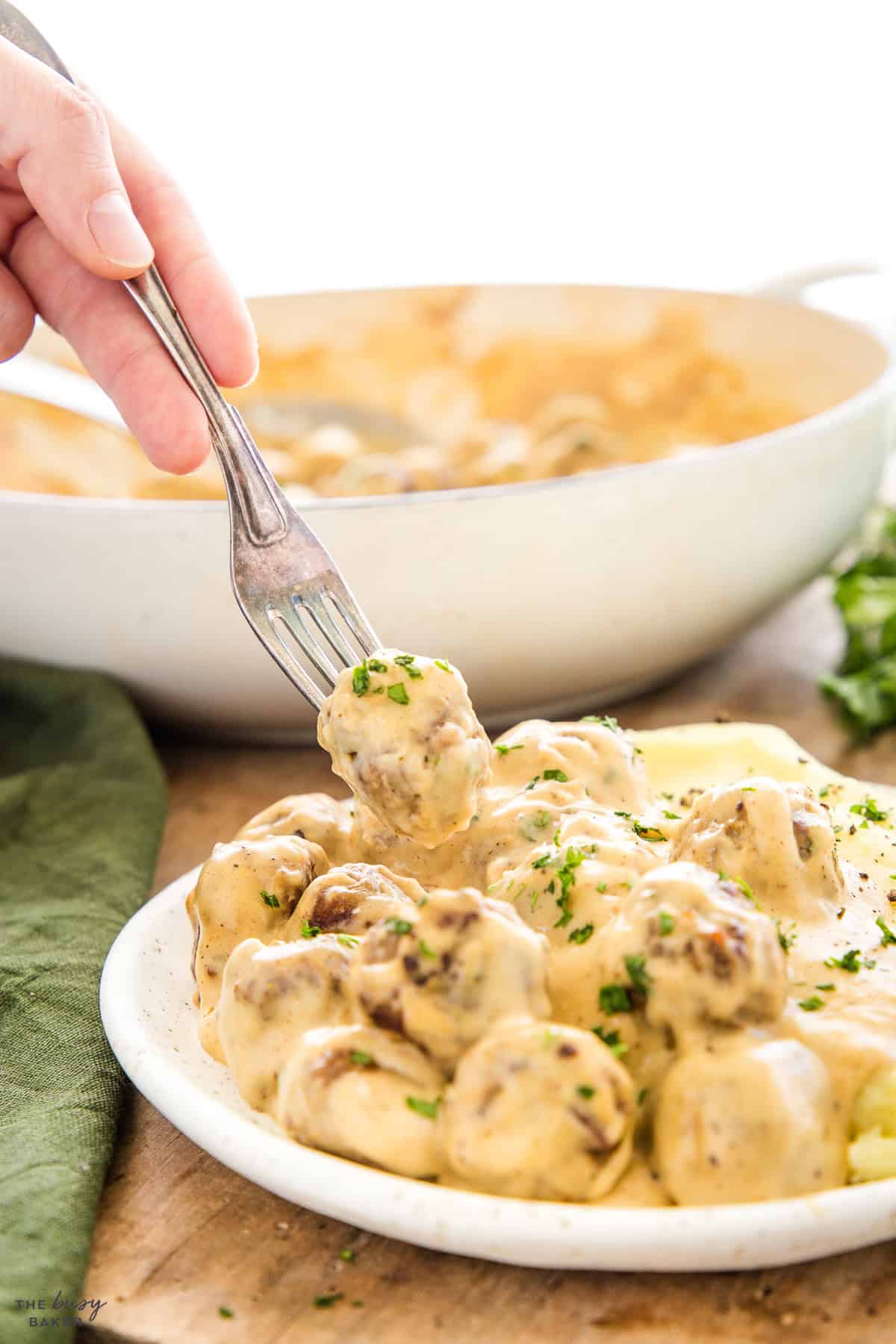 fork holding a swedish meatball with sauce