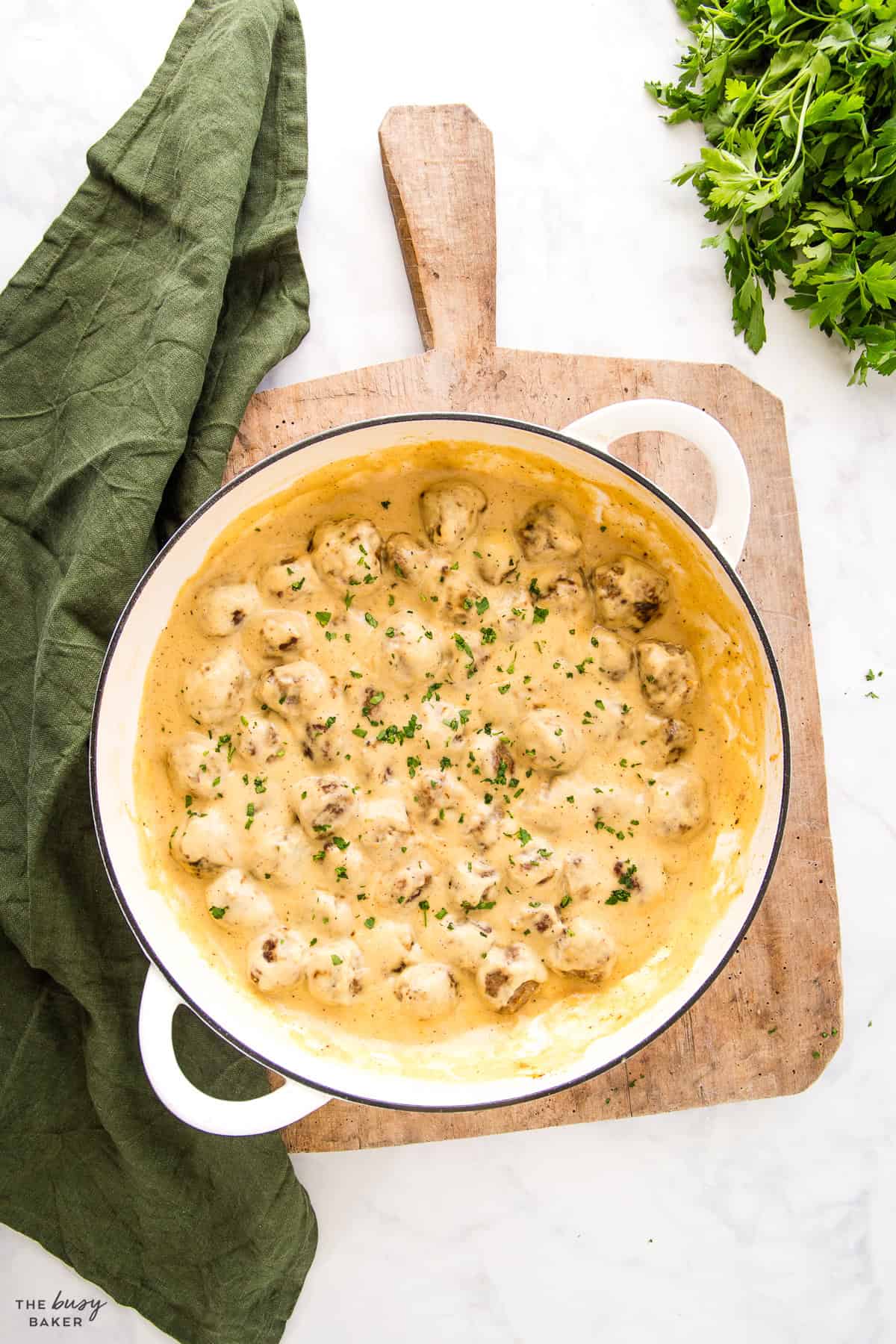 white cast iron pan with meatballs and gravy