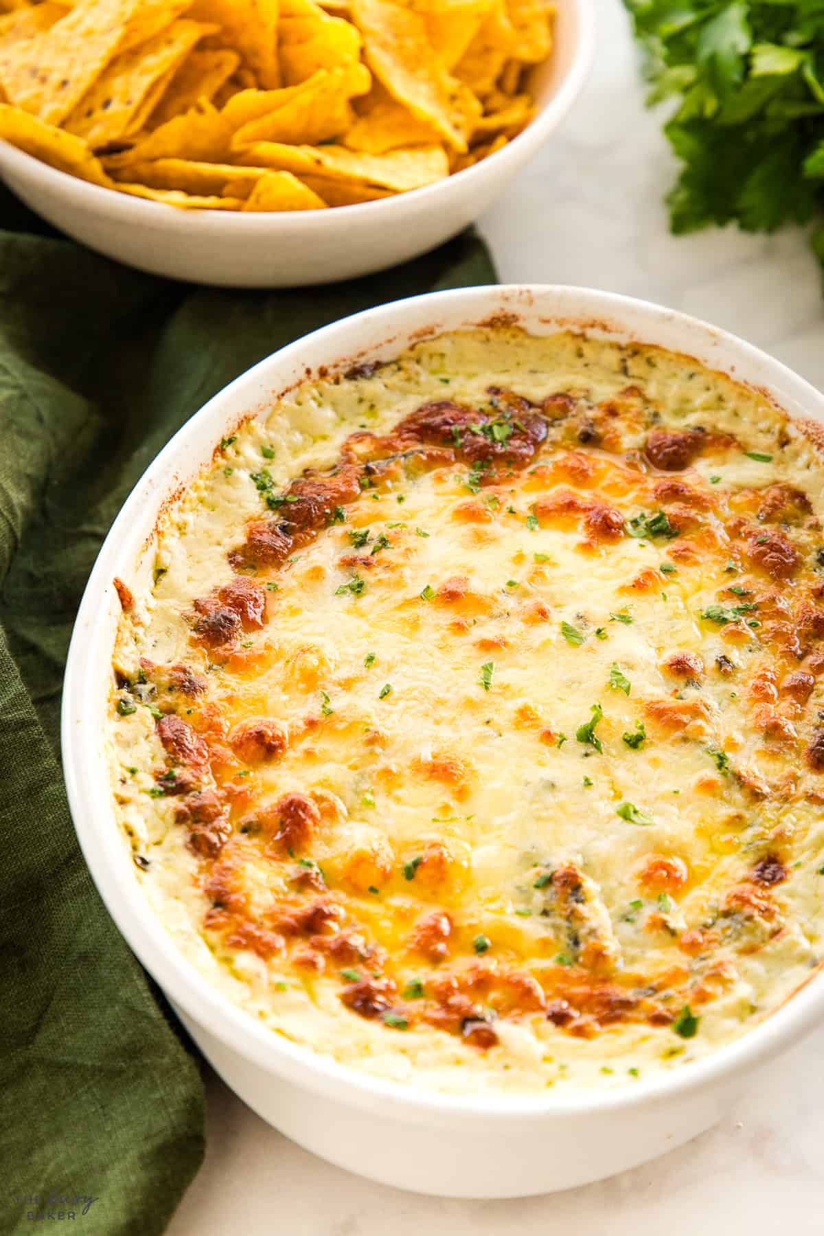 baked spinach and artichoke dip in a white baking dish