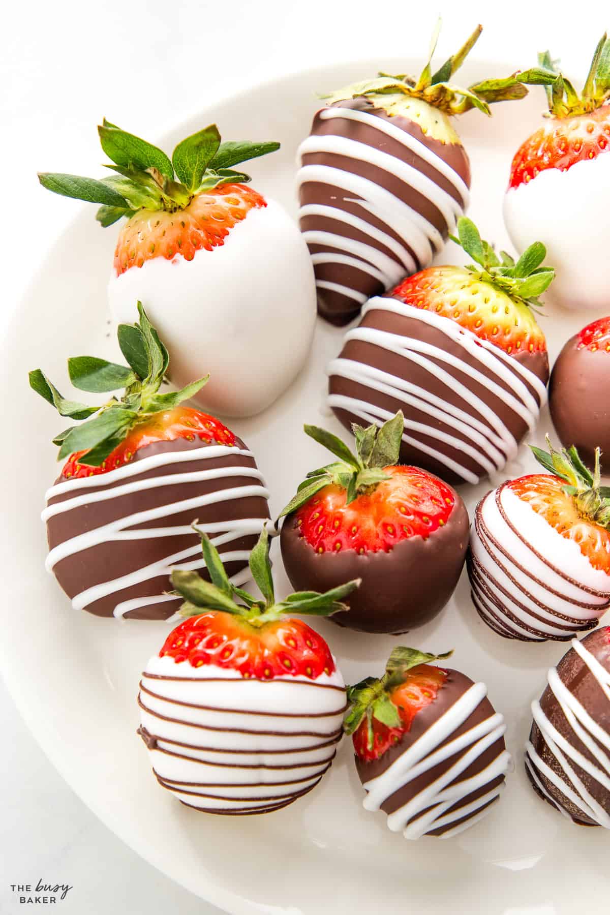 chocolate covered strawberries on a plate with white and dark chocolate