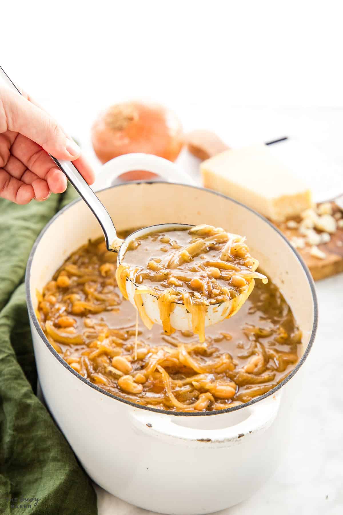 a ladle full of french onion white bean soup