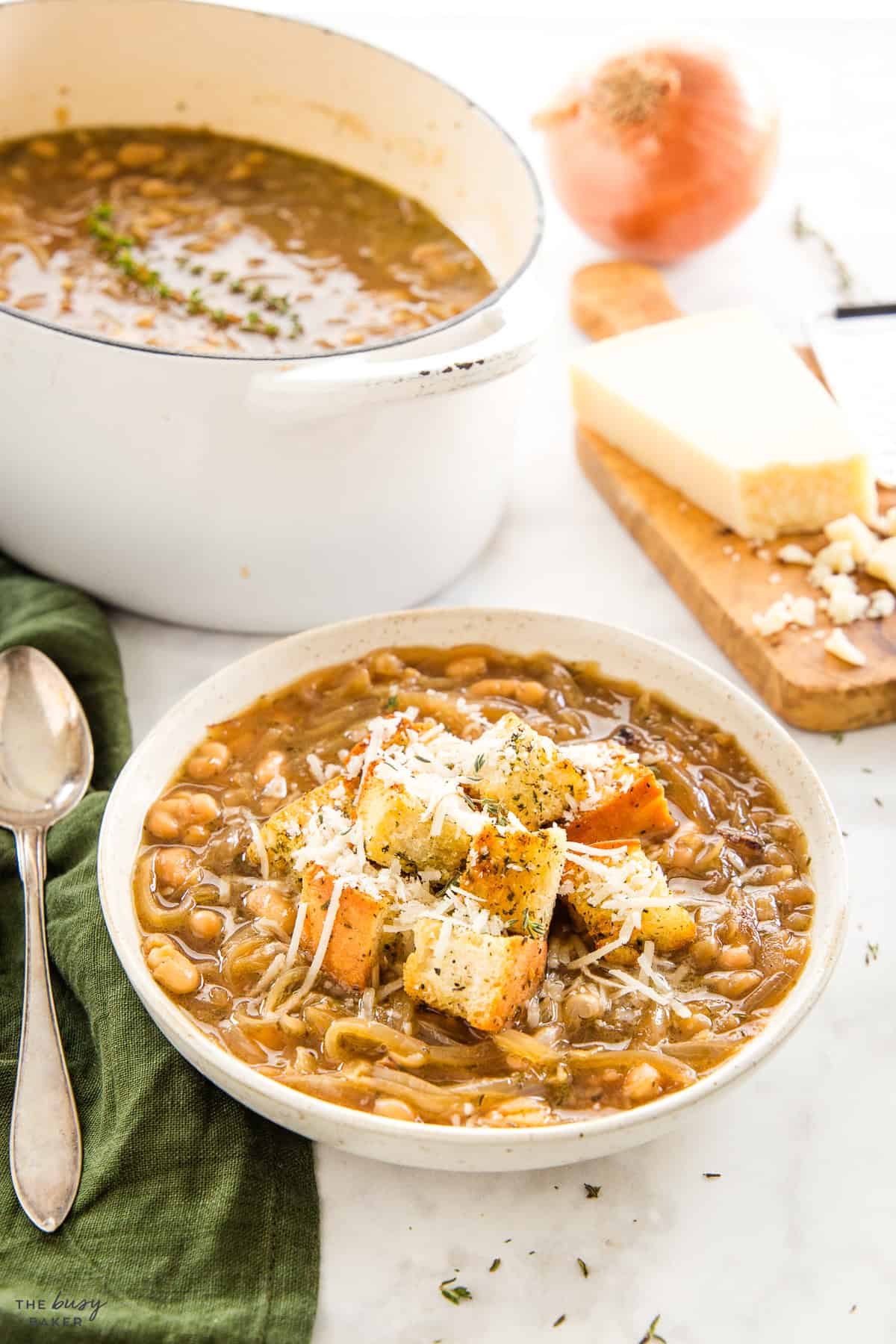 bowl of white bean french onion soup with croutons and Parmesan