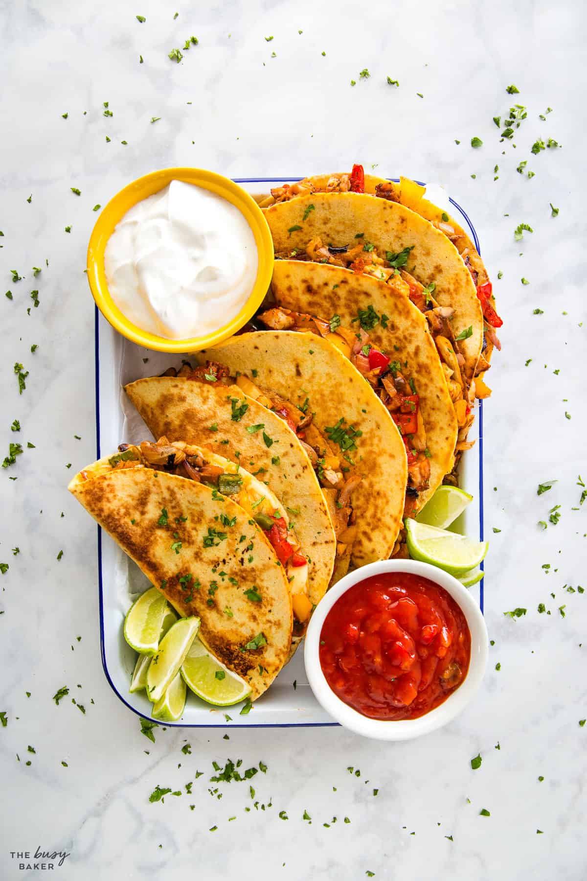 overhead image: quesadillas on a tray with salsa and sour cream