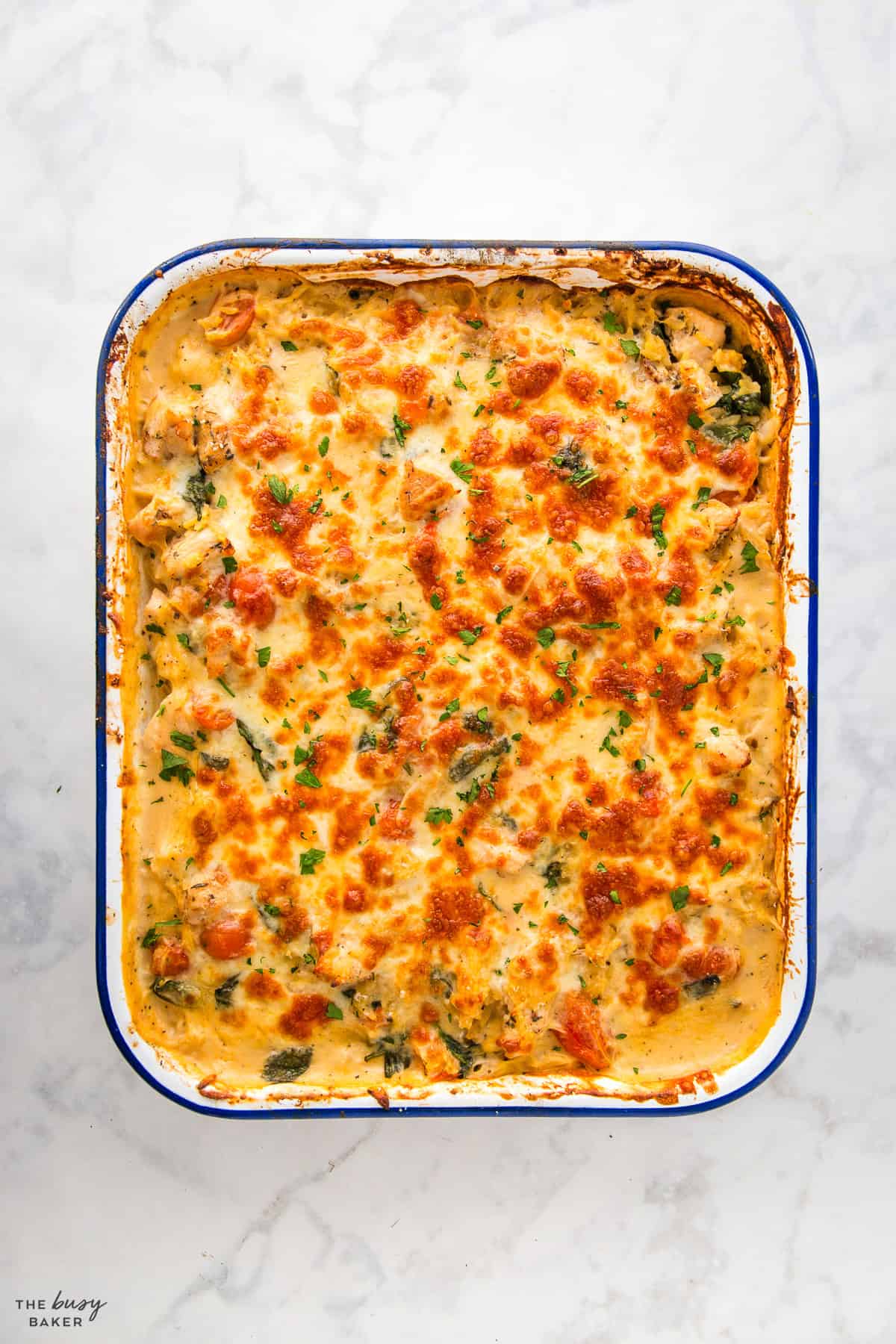 overhead image: cheesy casserole recipe in a blue-rimmed baking dish