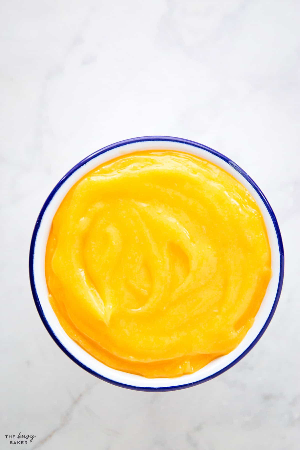 overhead image: lemon curd in a blue rimmed bowl