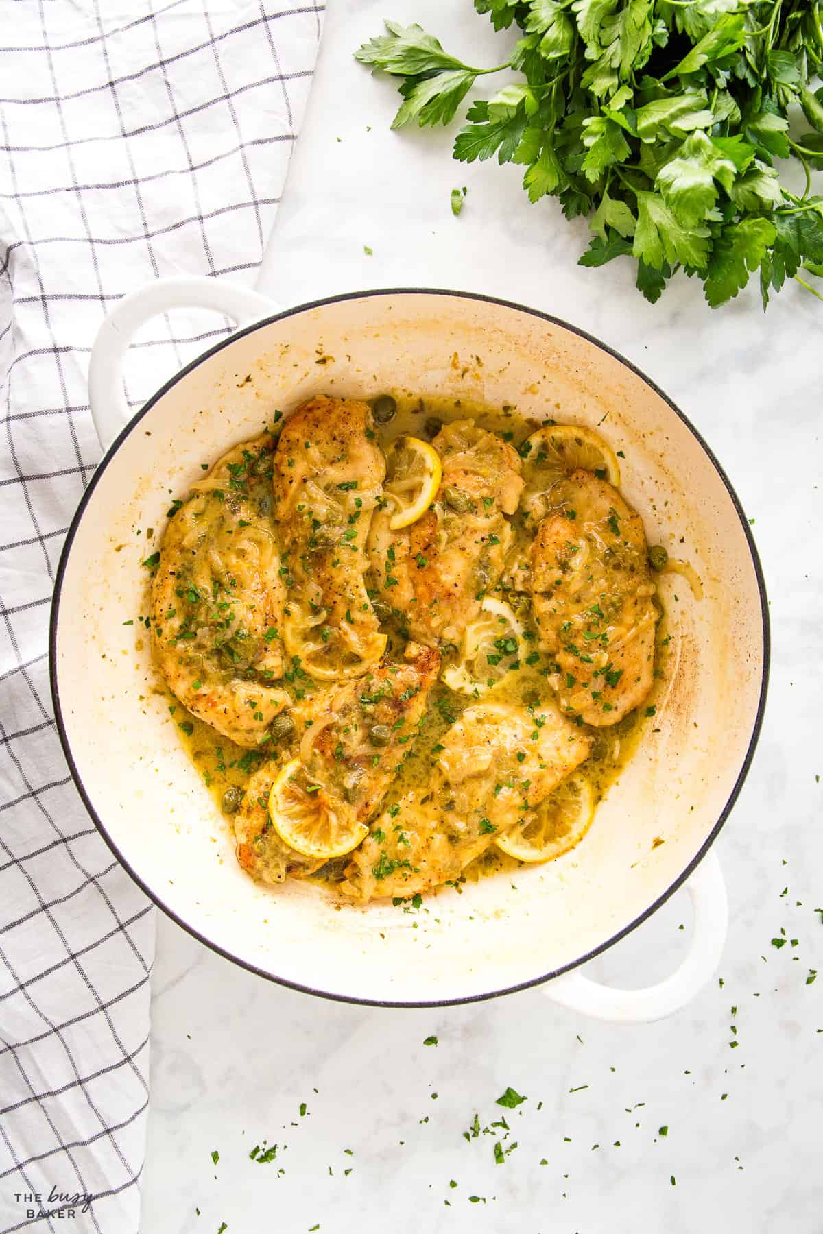 overhead image: chicken piccata in a white cast iron pan
