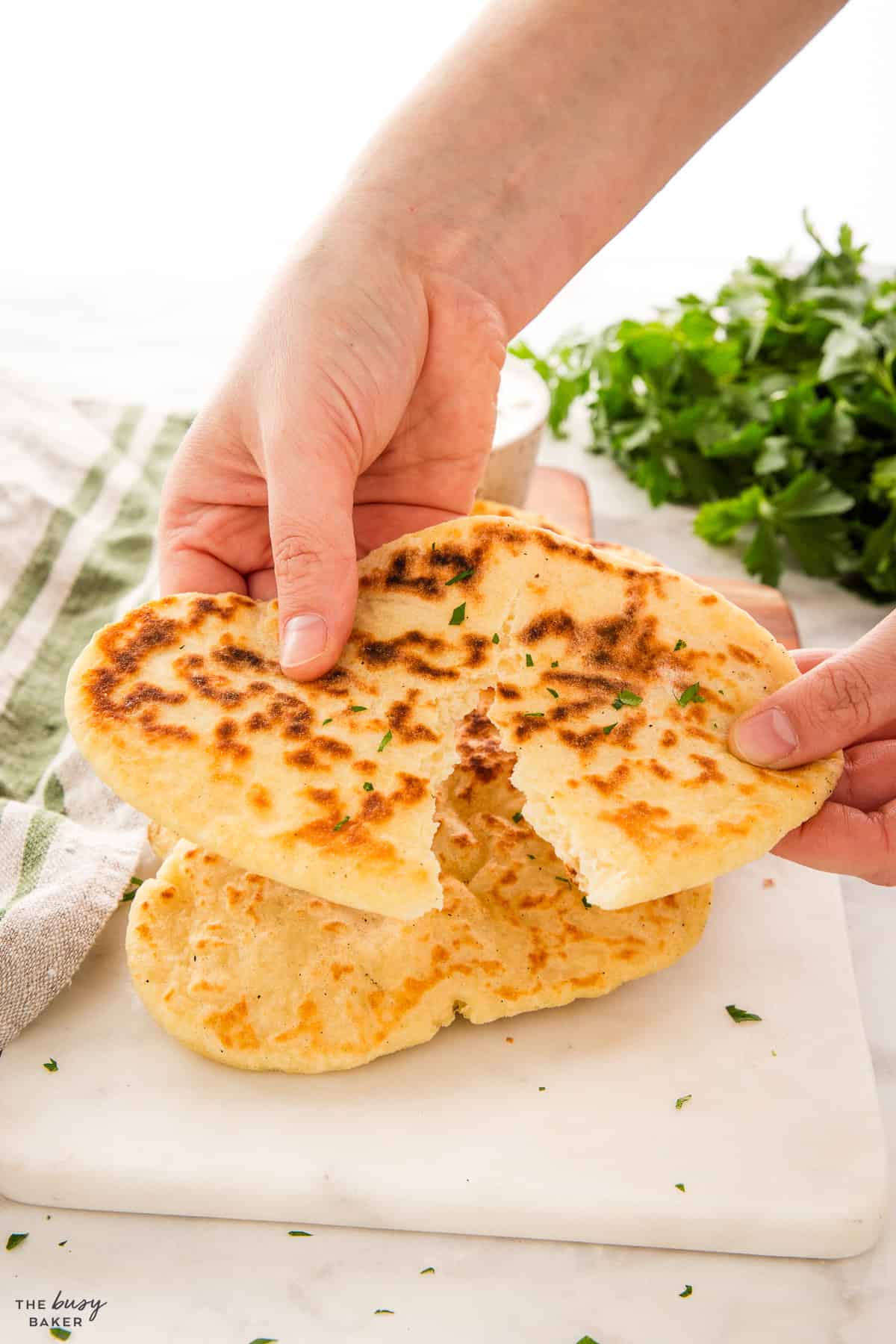 hands tearing a flatbread recipe