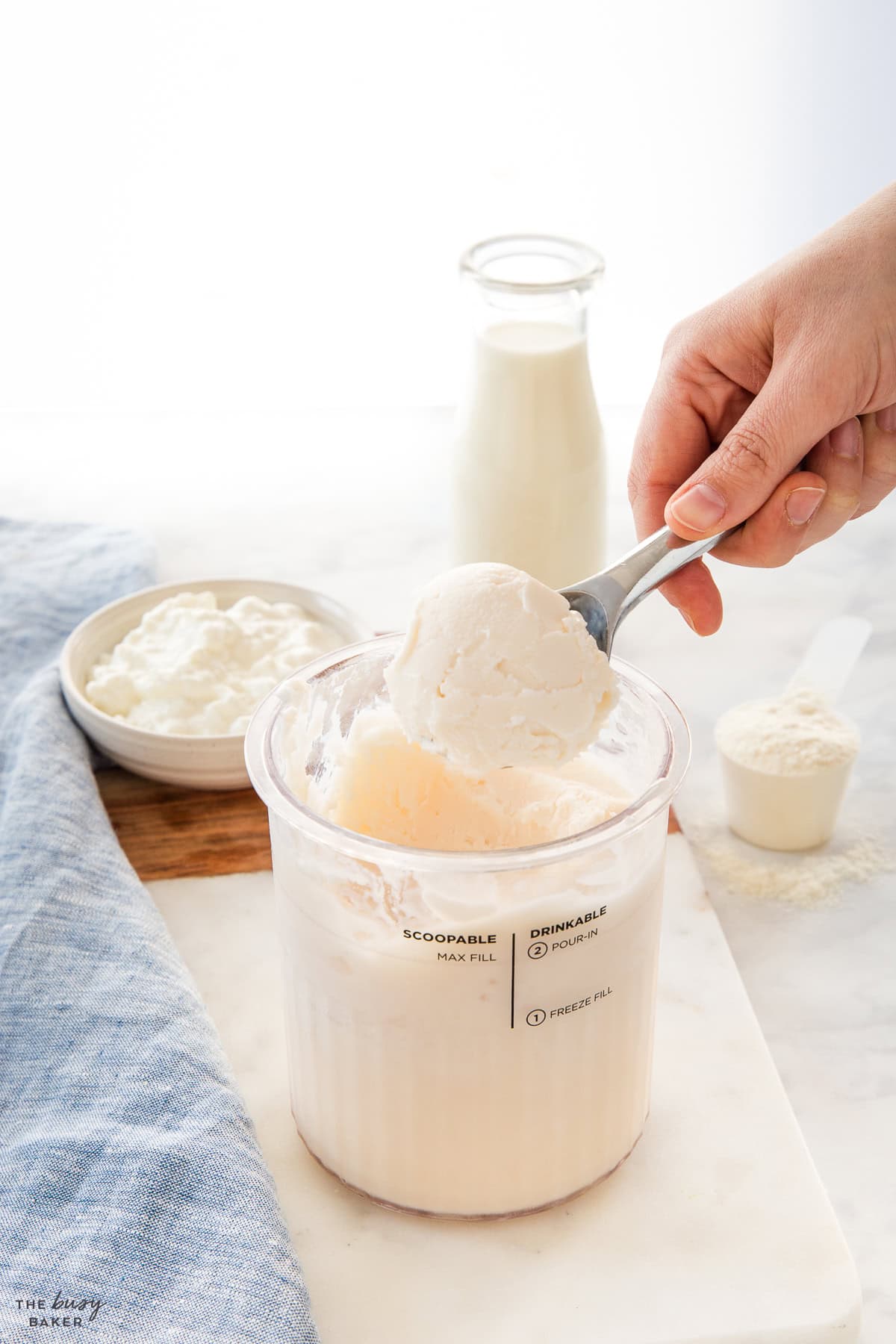 hand serving vanilla protein ice cream in an ice cream scoop