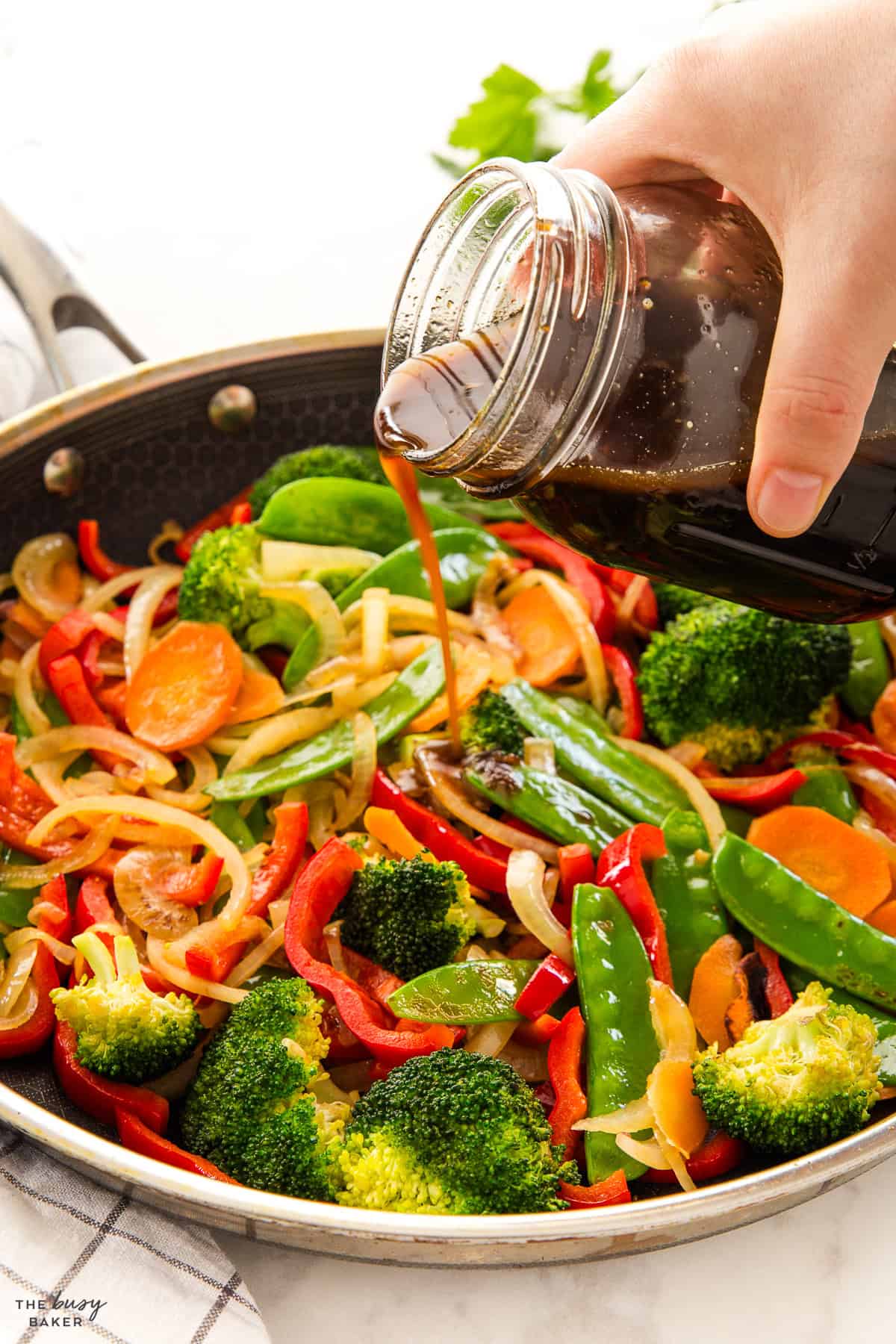 stir fry sauce pouring into a stir fry