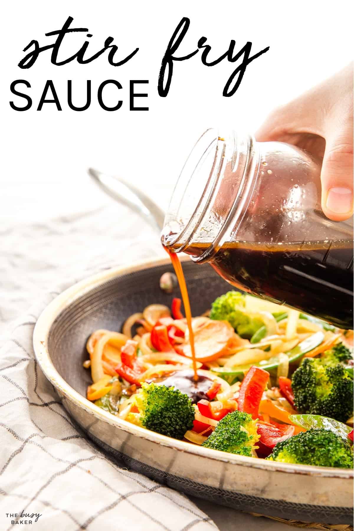 hand pouring stir fry sauce into a stir fry from a mason jar