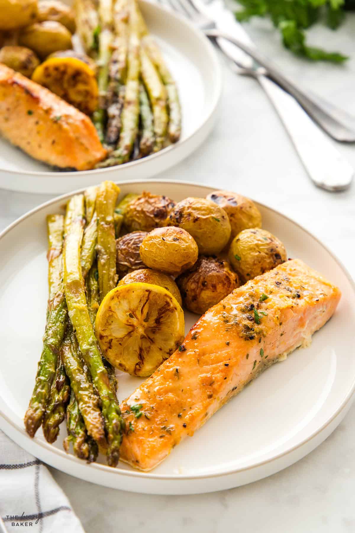 baked salmon, asparagus, and potatoes on a white plate