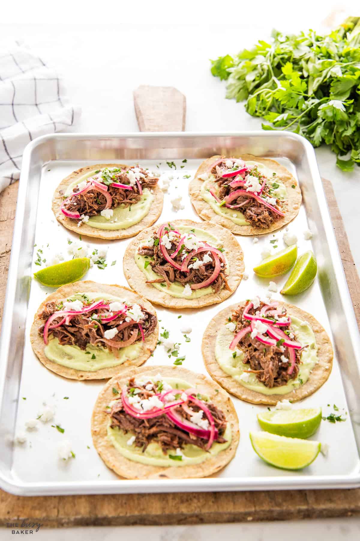 shredded beef tacos with limes and pickled onions