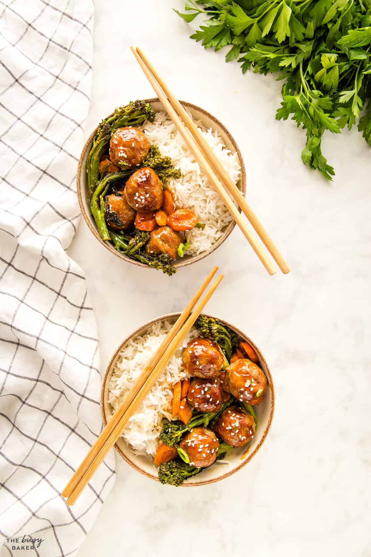 overhead image: meatballs, veggies and rice on bowls with chopsticks