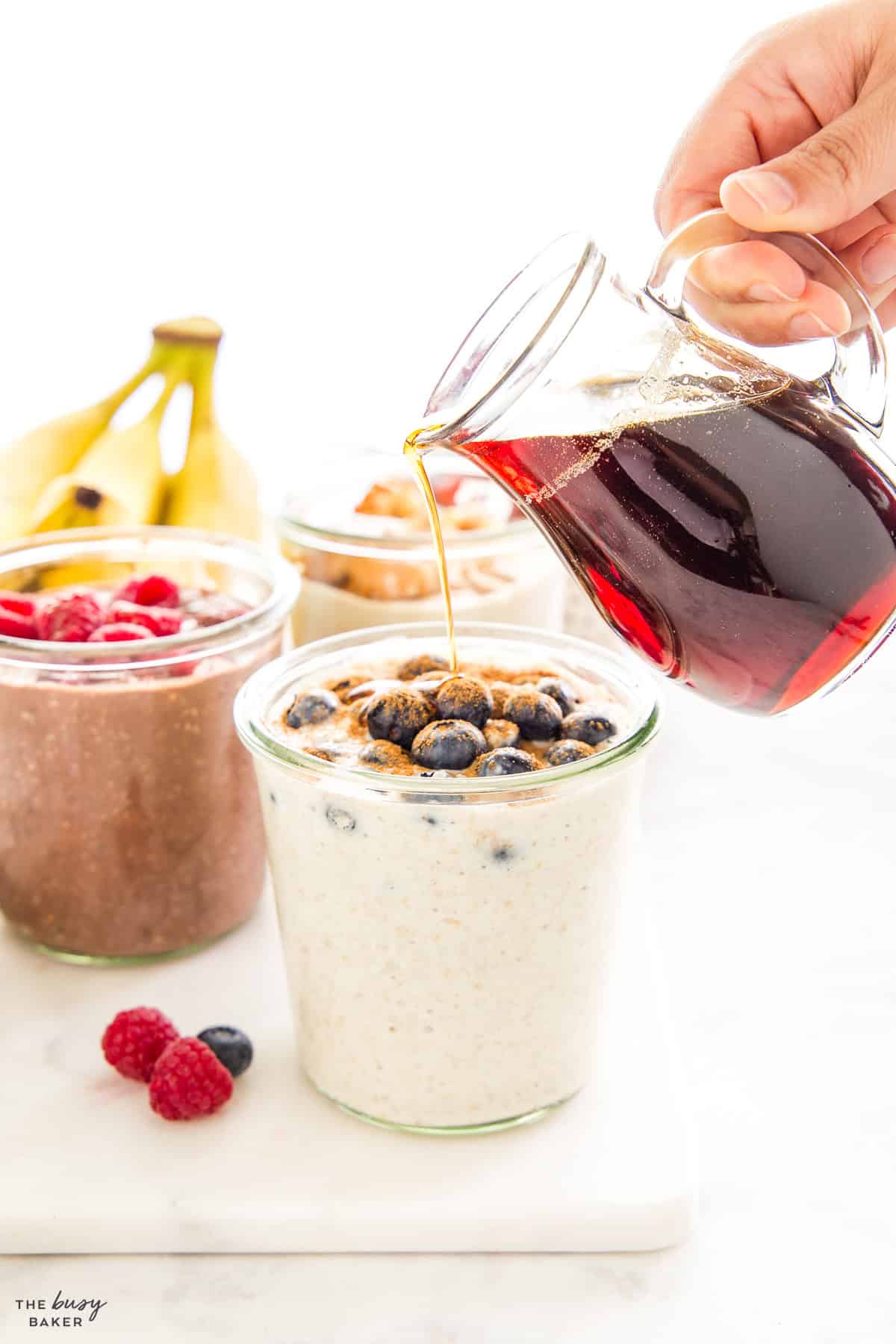 maple syrup being poured over overnight oats