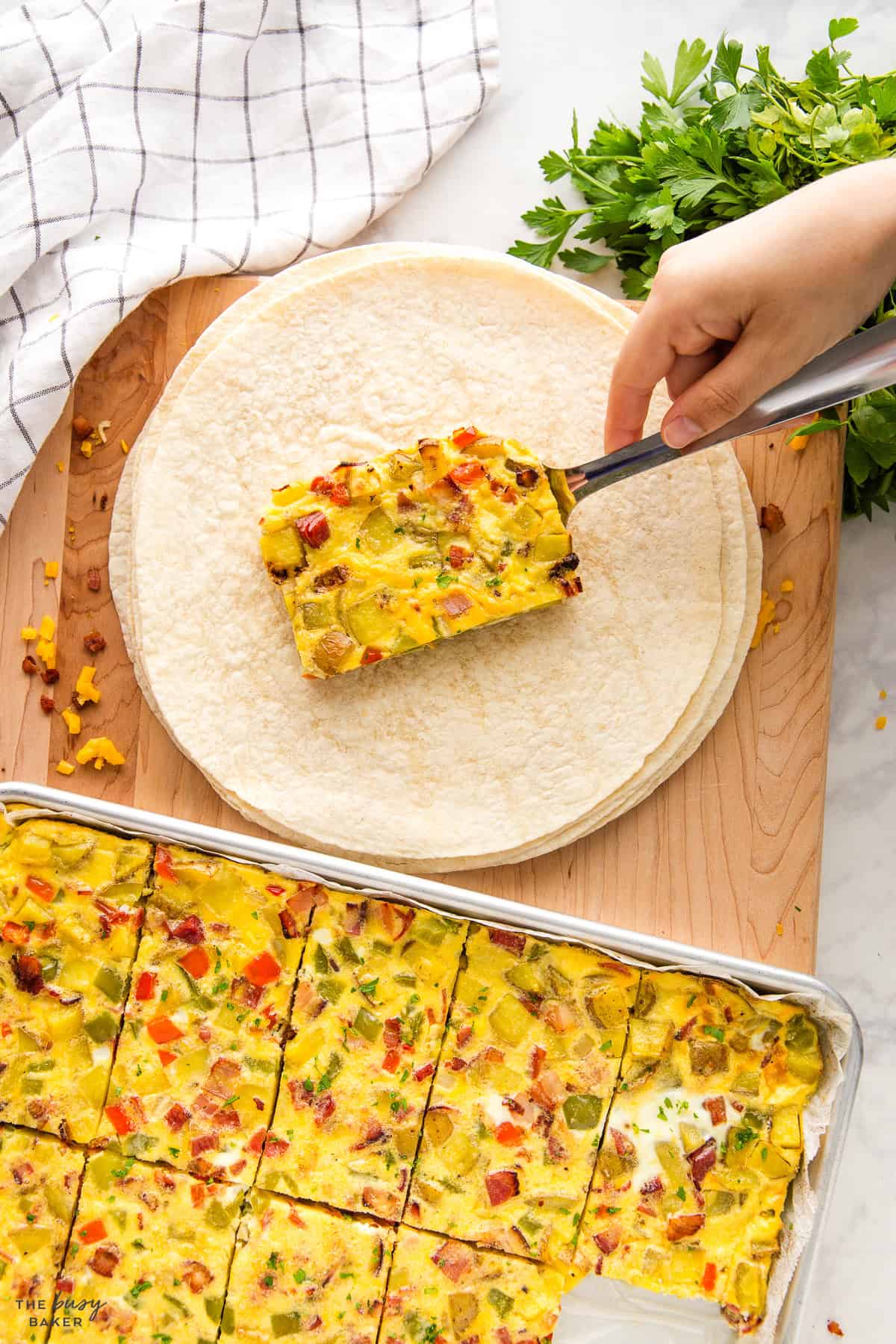 assembling a breakfast burrito with egg and potato filling