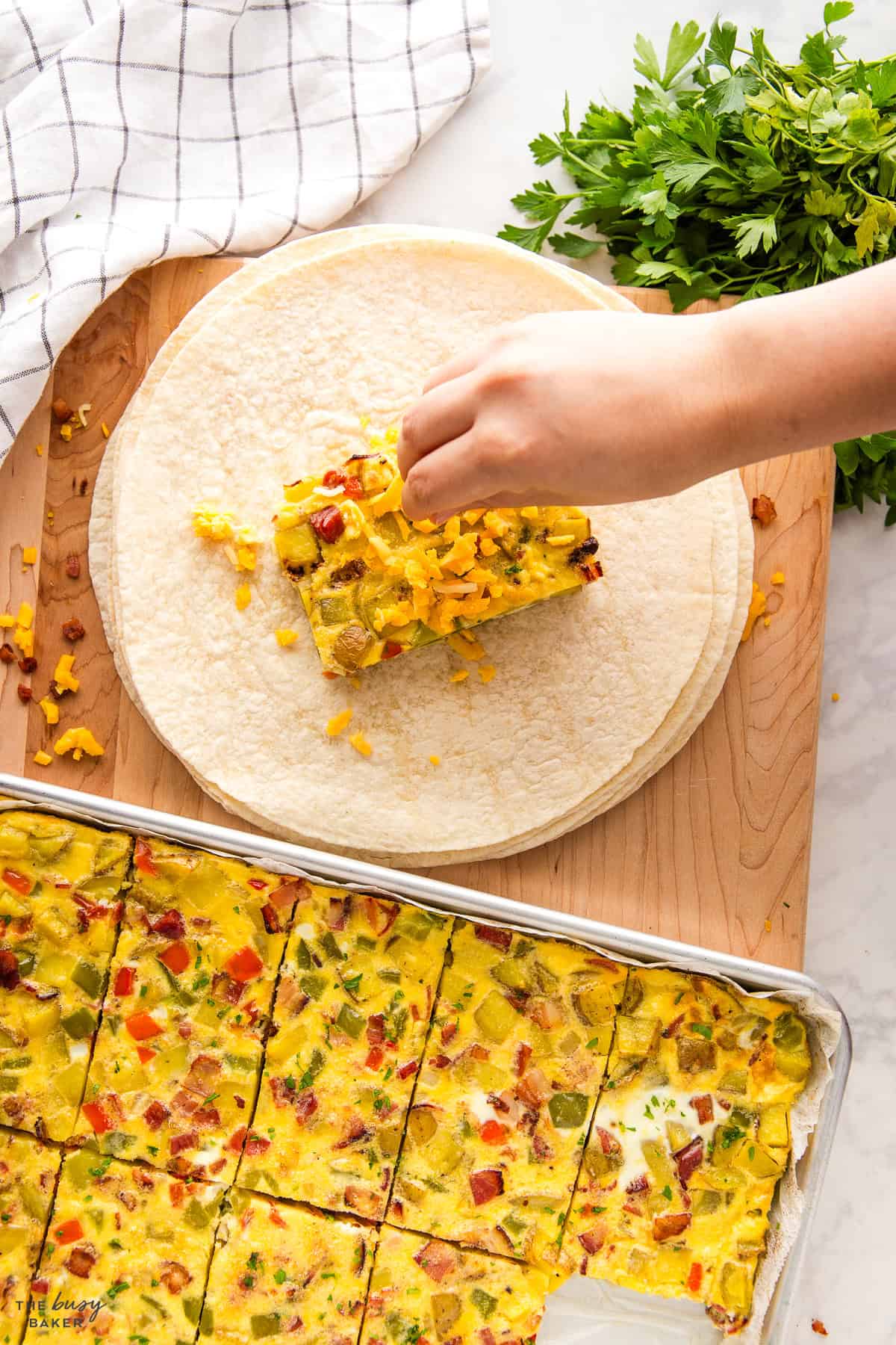 adding cheese to a breakfast burrito