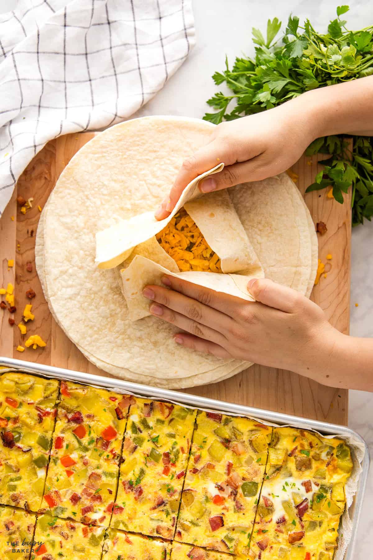 assembling a breakfast burrito on a wooden board
