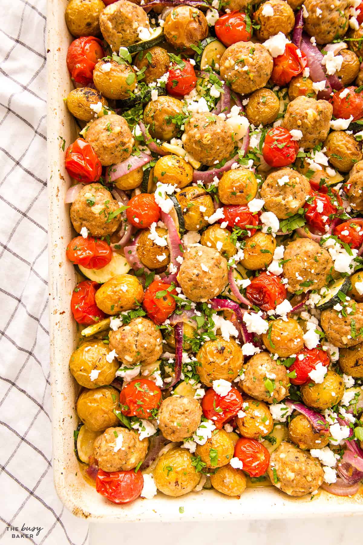 easy sheet pan dinner recipe with meatballs, veggies. and feta