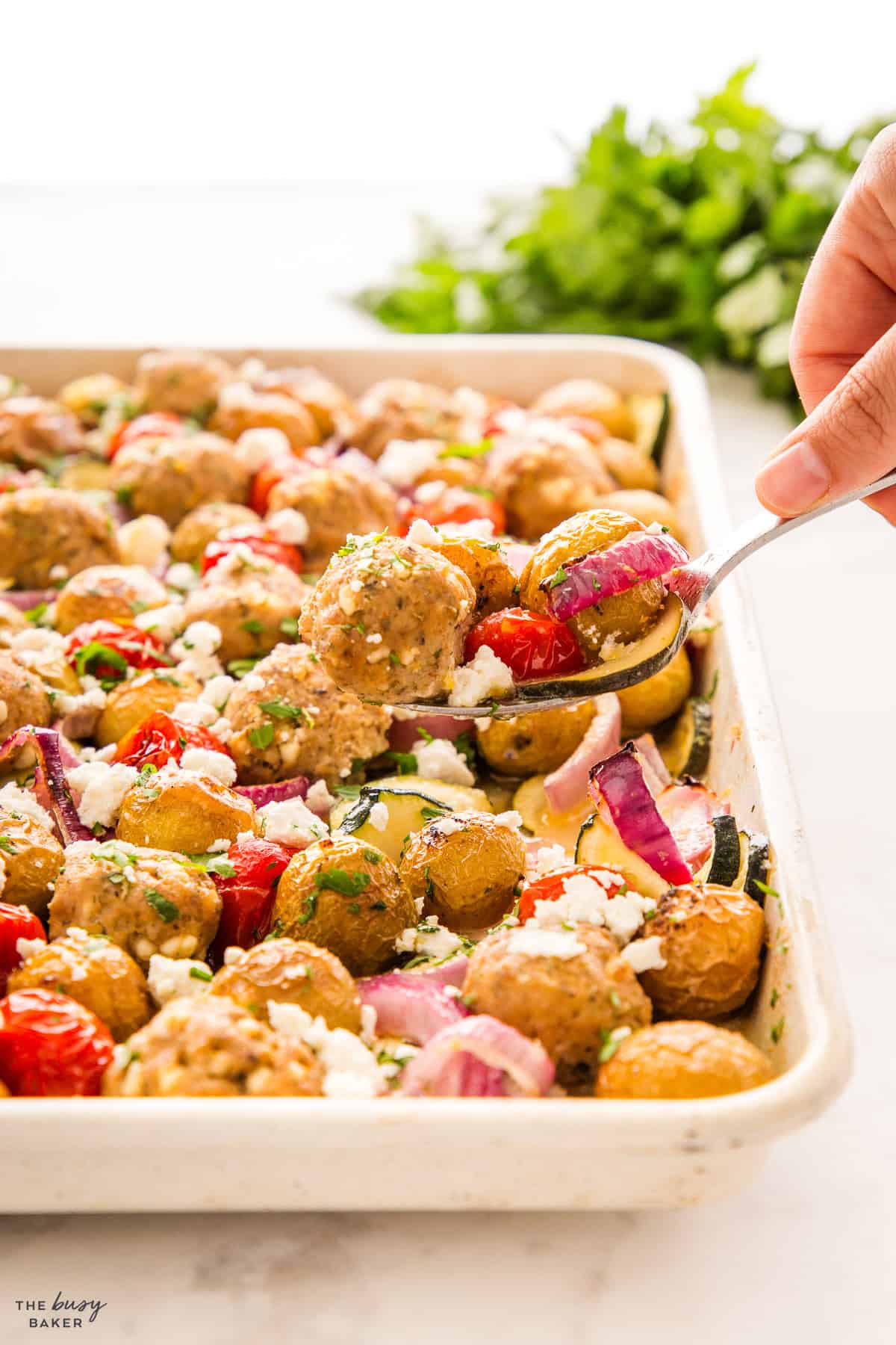 meatballs and potatoes with veggies on a sheet pan