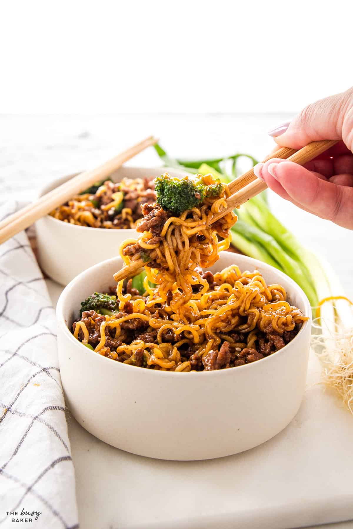 hand holding chopsticks serving beef and broccoli ramen