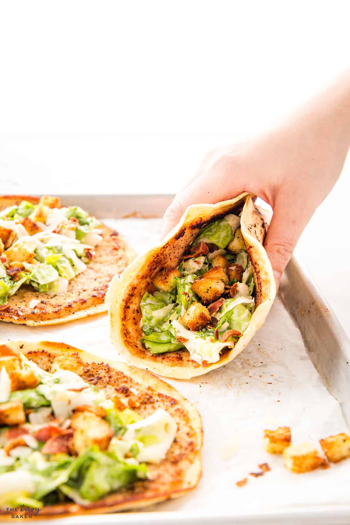 hand holding a chicken caesar taco