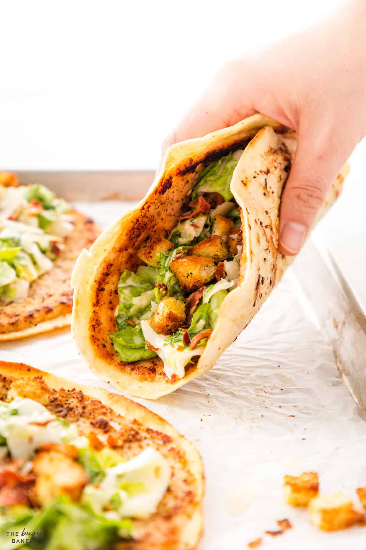 hand holding chicken caesar taco