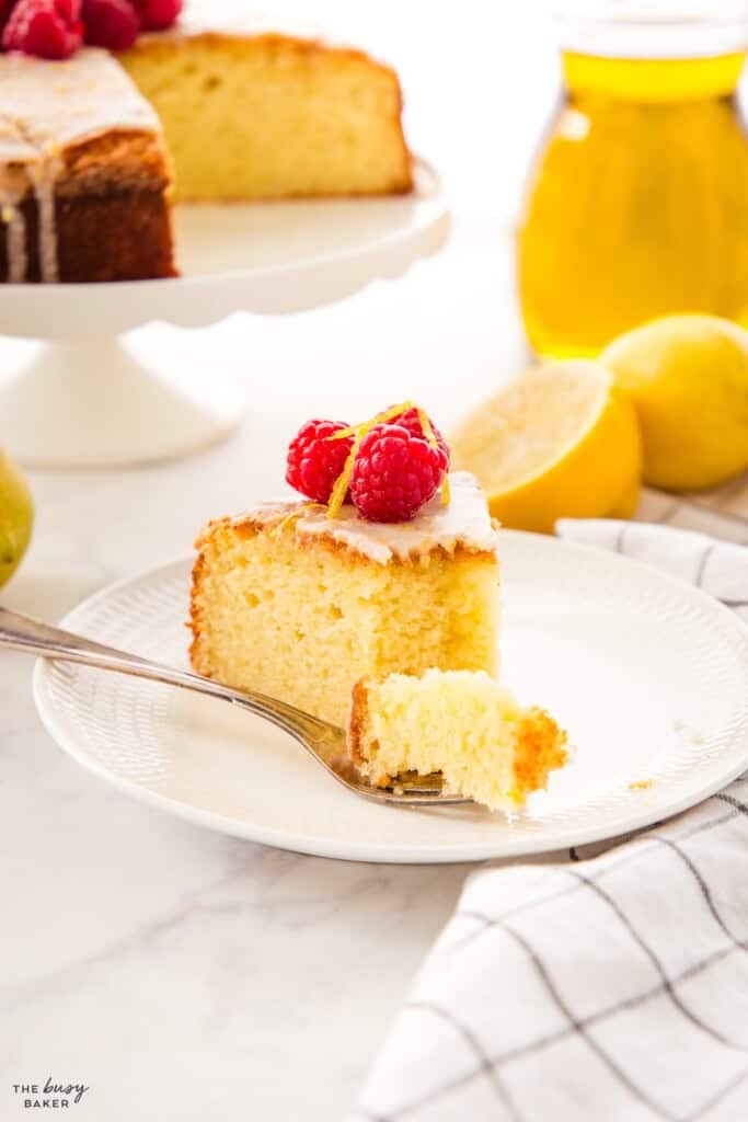 bite of tender olive oil cake on a white plate
