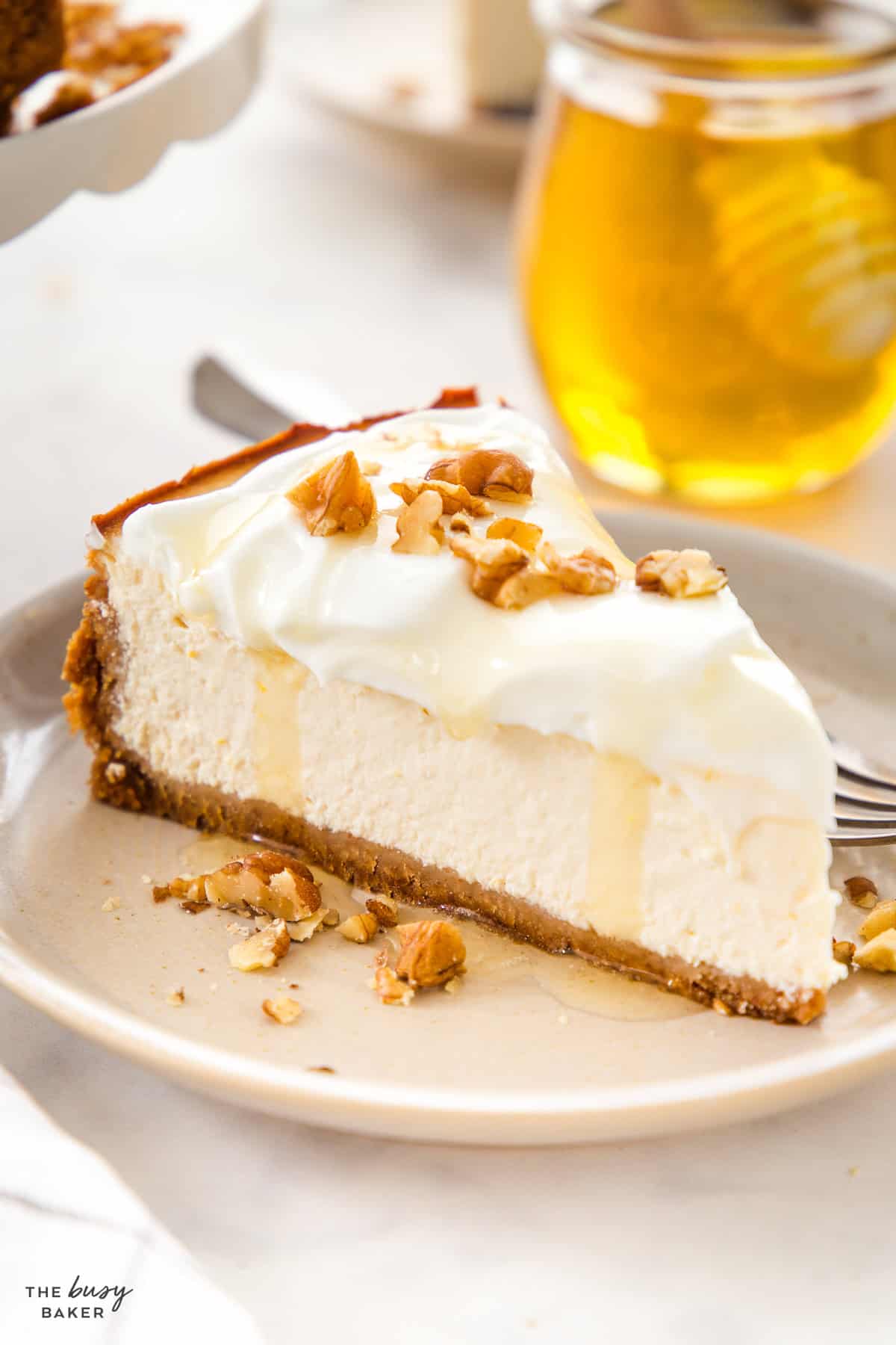 Slice of healthy Greek yogurt cheesecake with honey drizzle and chopped walnuts